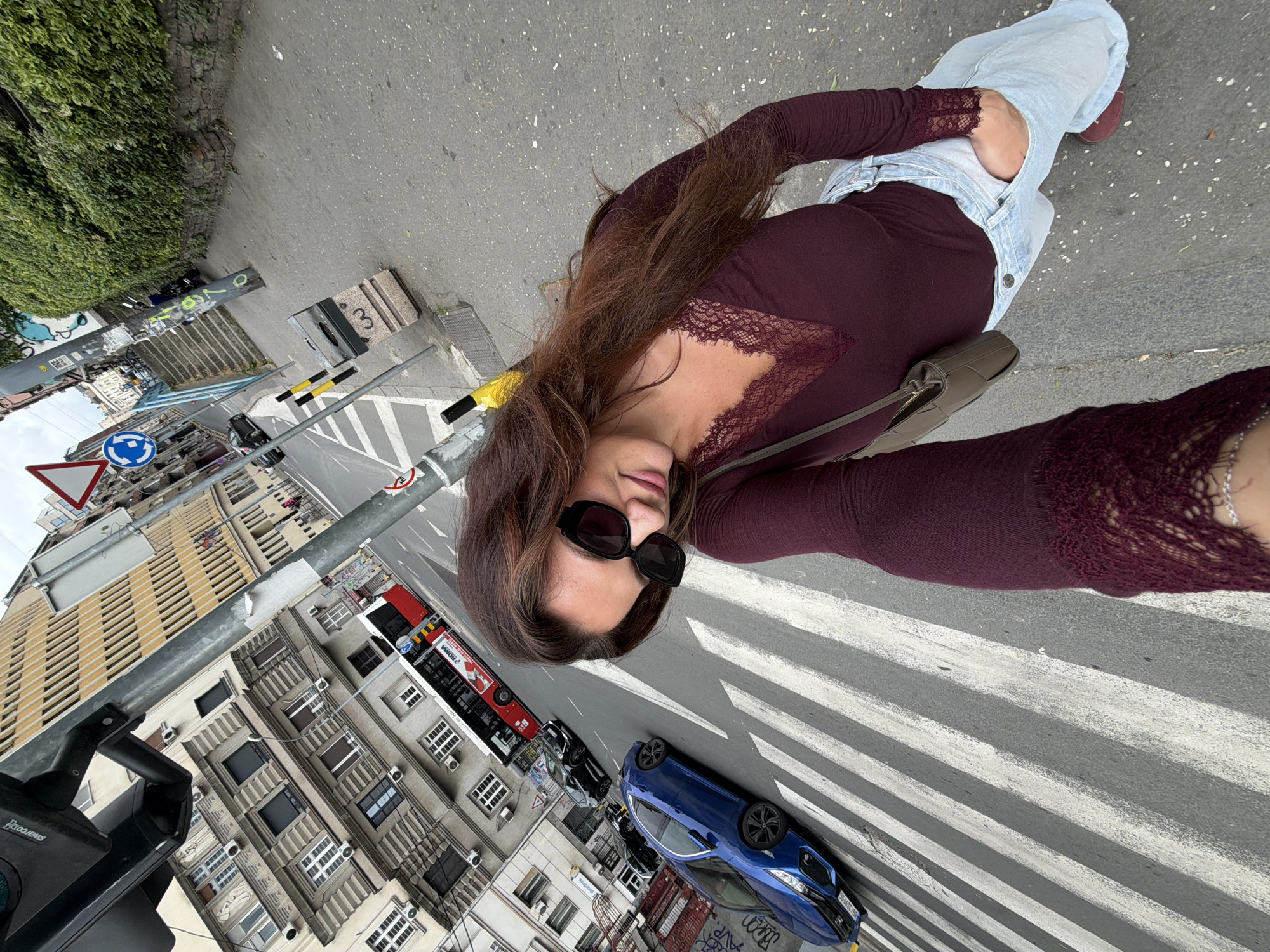 Woman takes selfie on Belgrade crosswalk, walks nearby sidewalk