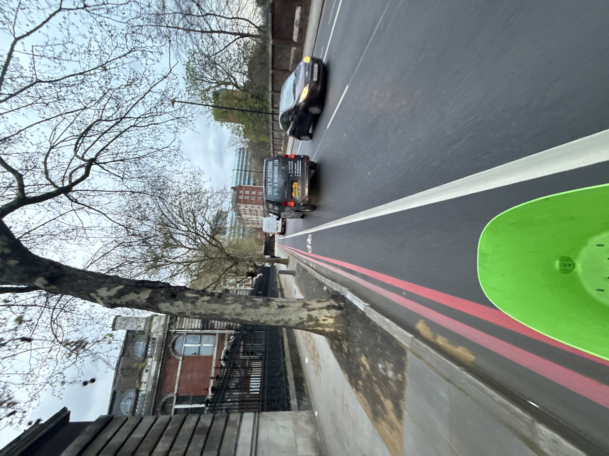 London street scene shows traffic and trees