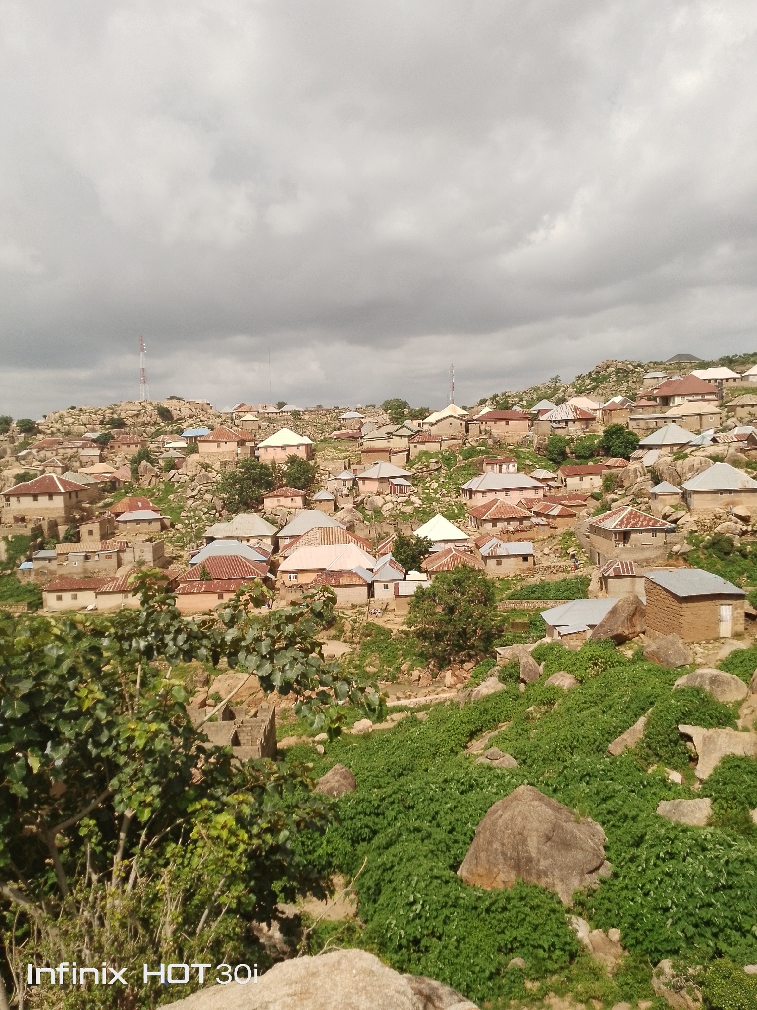 Rocky hillside village with boulders, cacti, and mud-brick homes