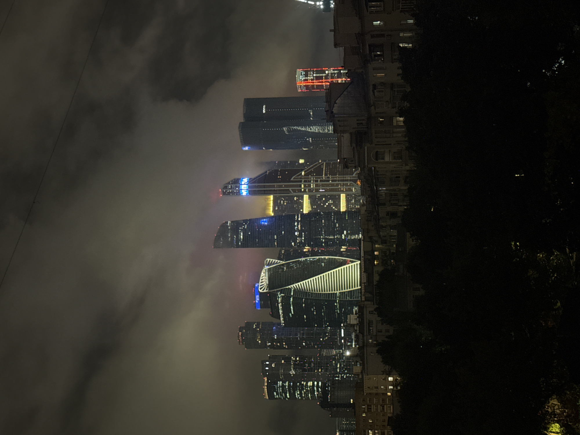 Moscow City skyline glows through fog on a misty summer night