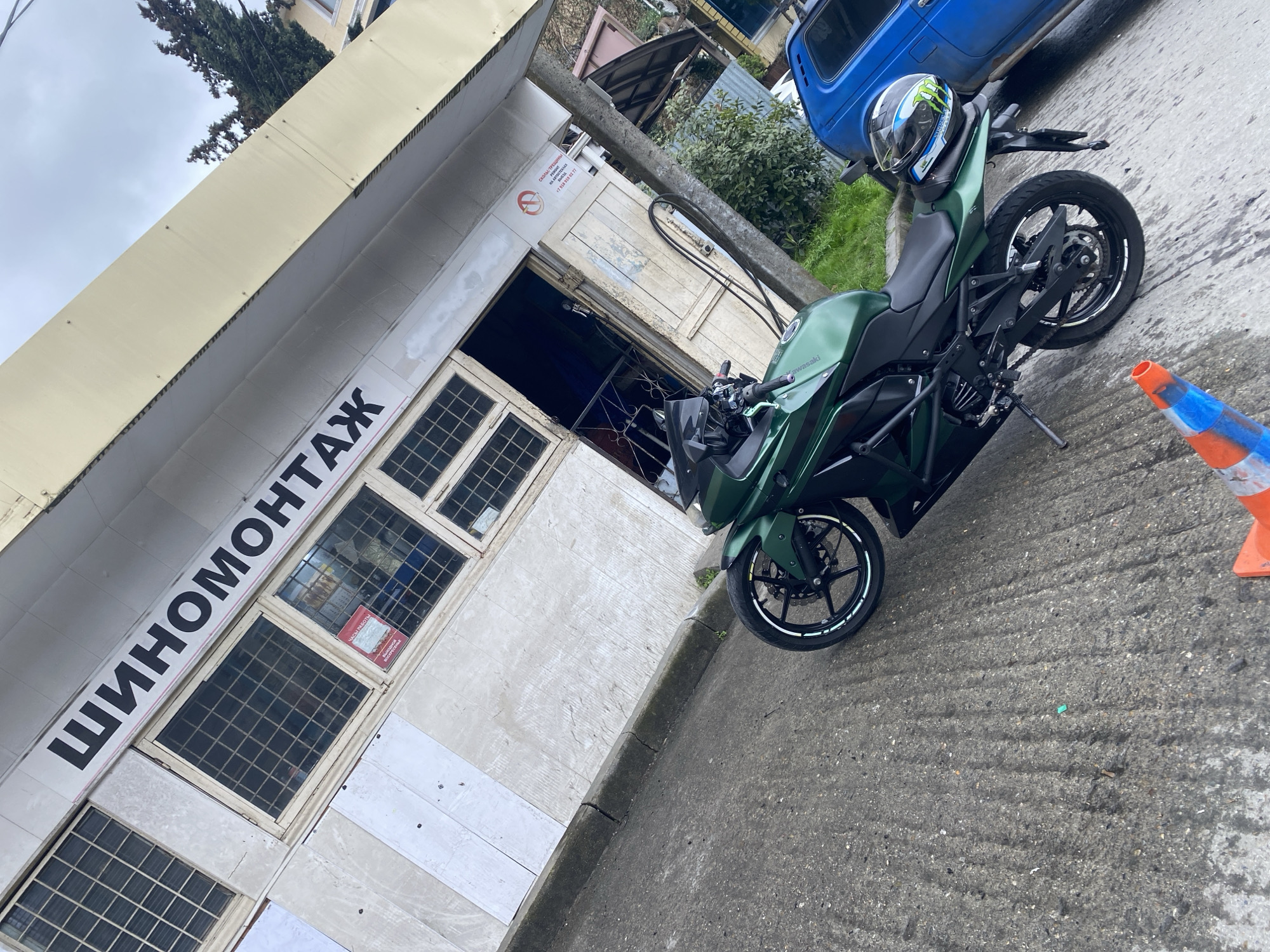 Motorcycle parked outside tire service shop in Sochi