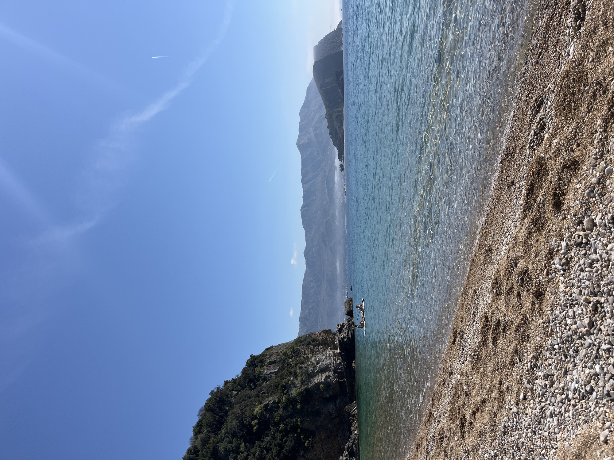Woman in polka dot dress relaxes on rocks at Budva beach