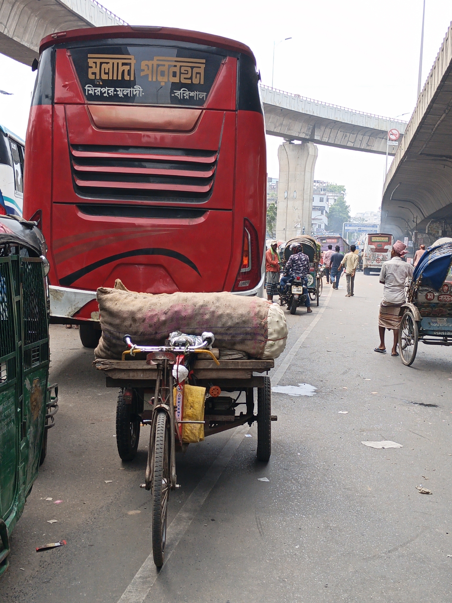 Morning street activity captured under Dhaka overpass
