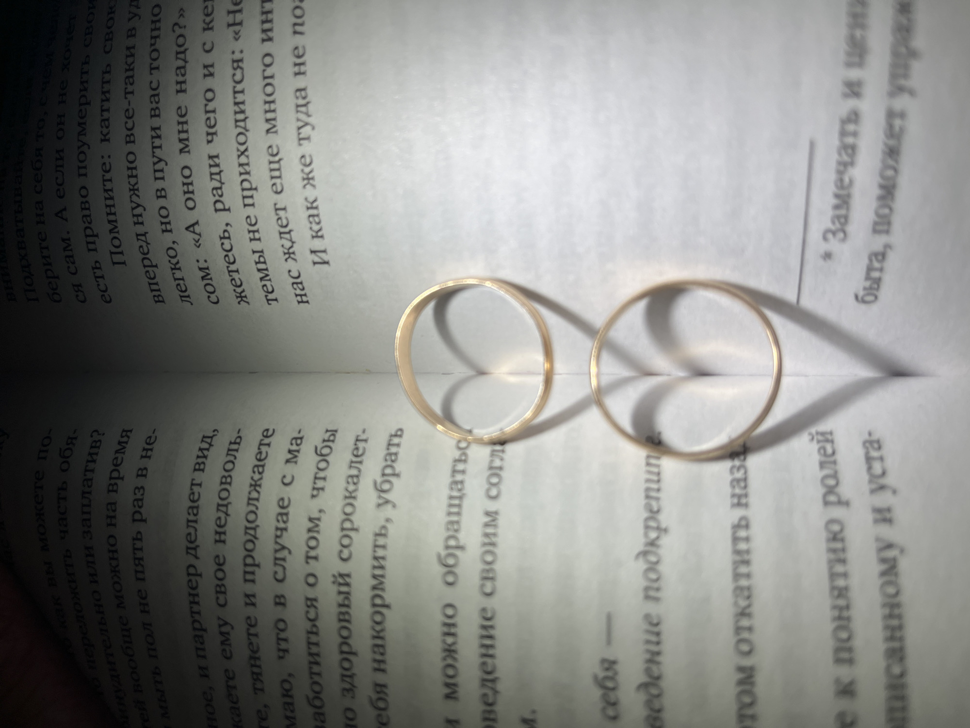 Wedding rings photographed on Russian book pages in Chaikovsky
