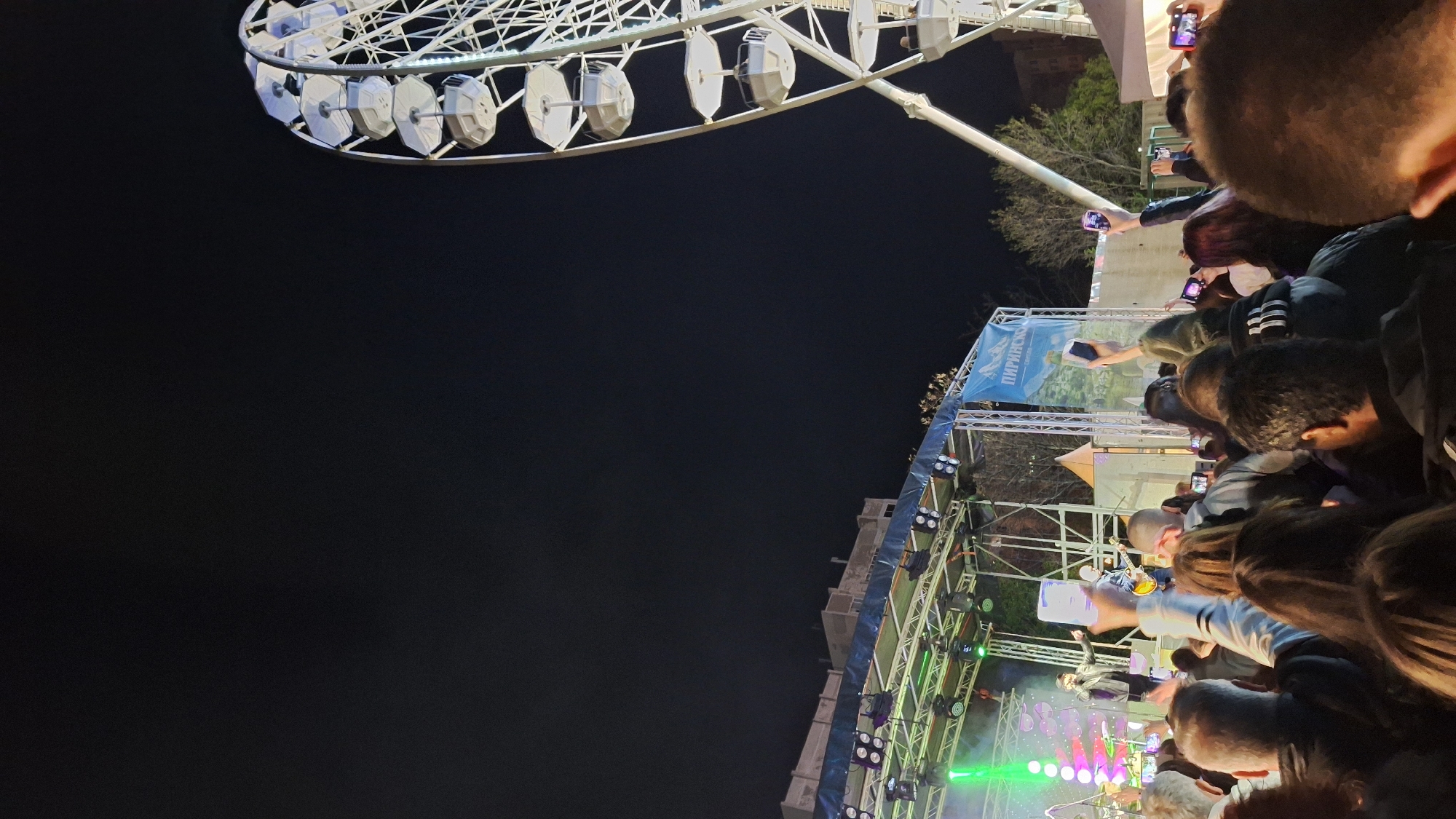 Crowd gathers with phones recording near Ferris wheel in Plovdiv