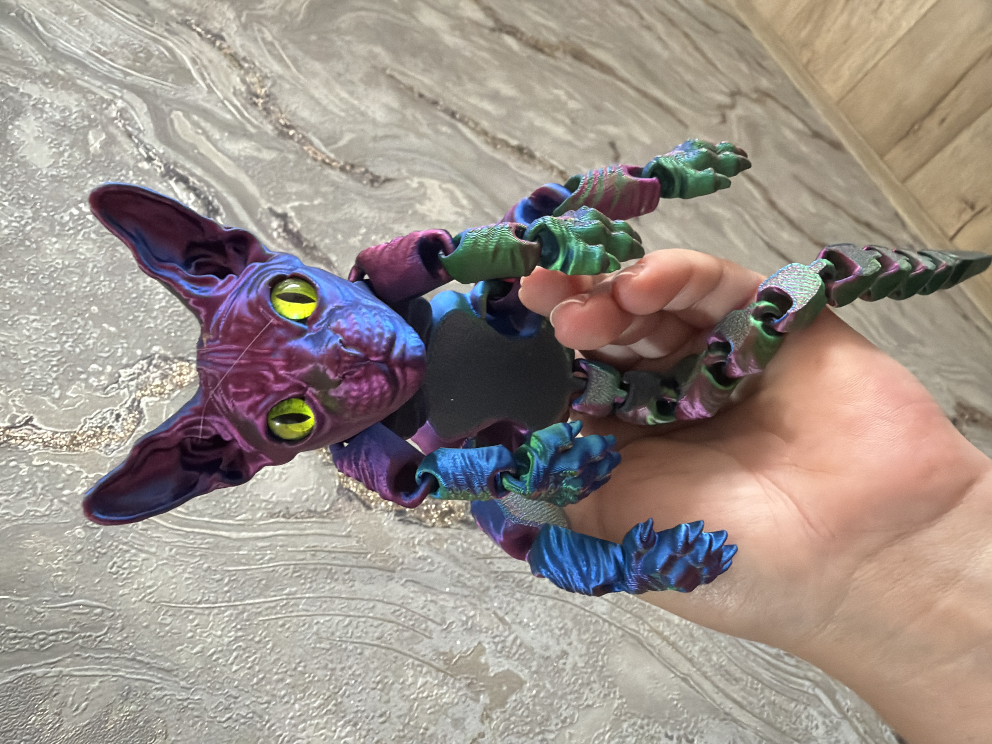 3D printed articulated cat figurines shown up close in hand