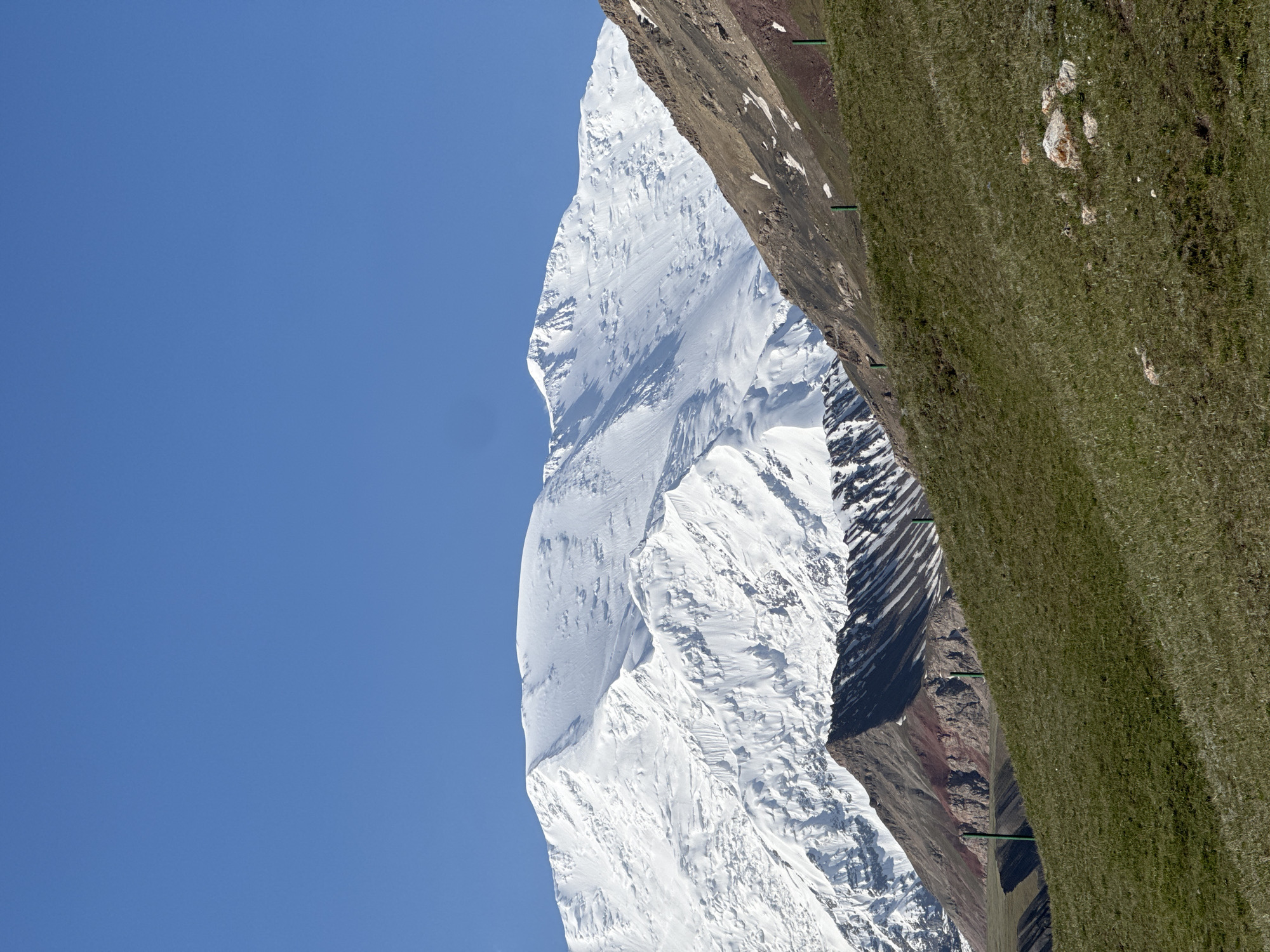 Snow-capped peaks and striated rock formations in Kyrgyzstan mountains