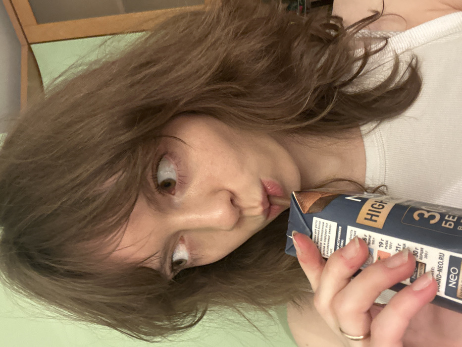 Young woman takes selfies during indoor photo session in Moscow