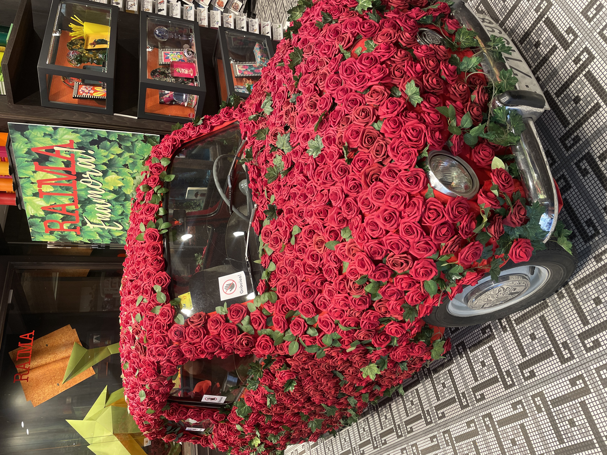 Rose-covered vintage Fiat 500 art installation displayed in Barcelona