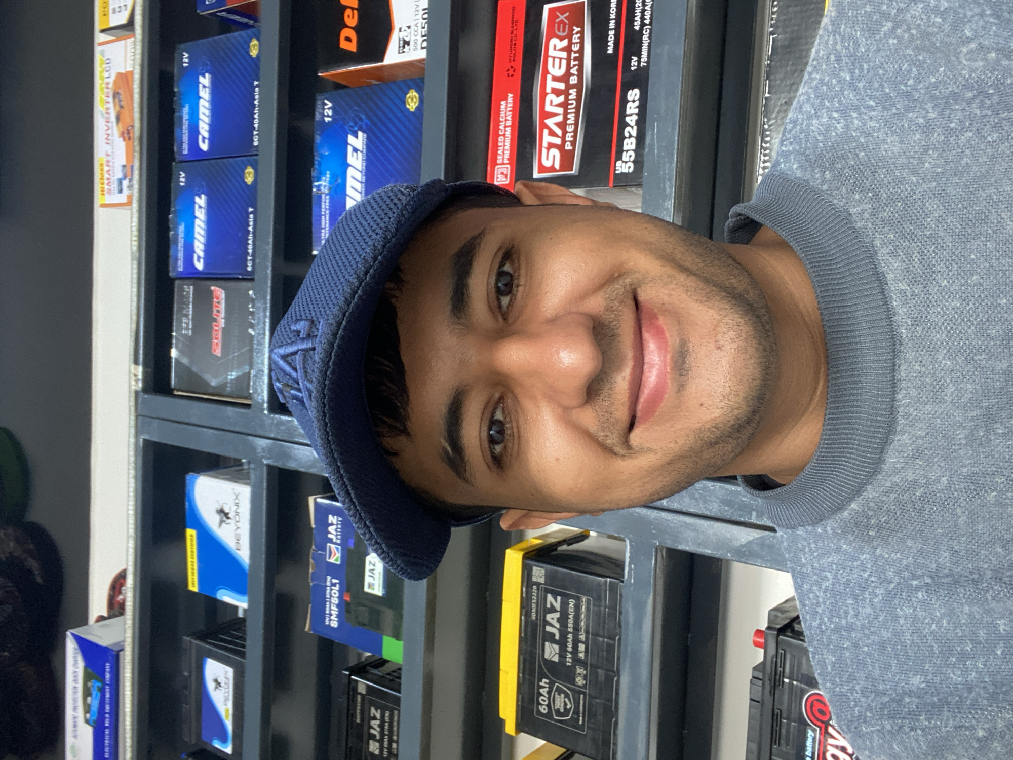 Man browses car batteries at Bukhara auto parts store