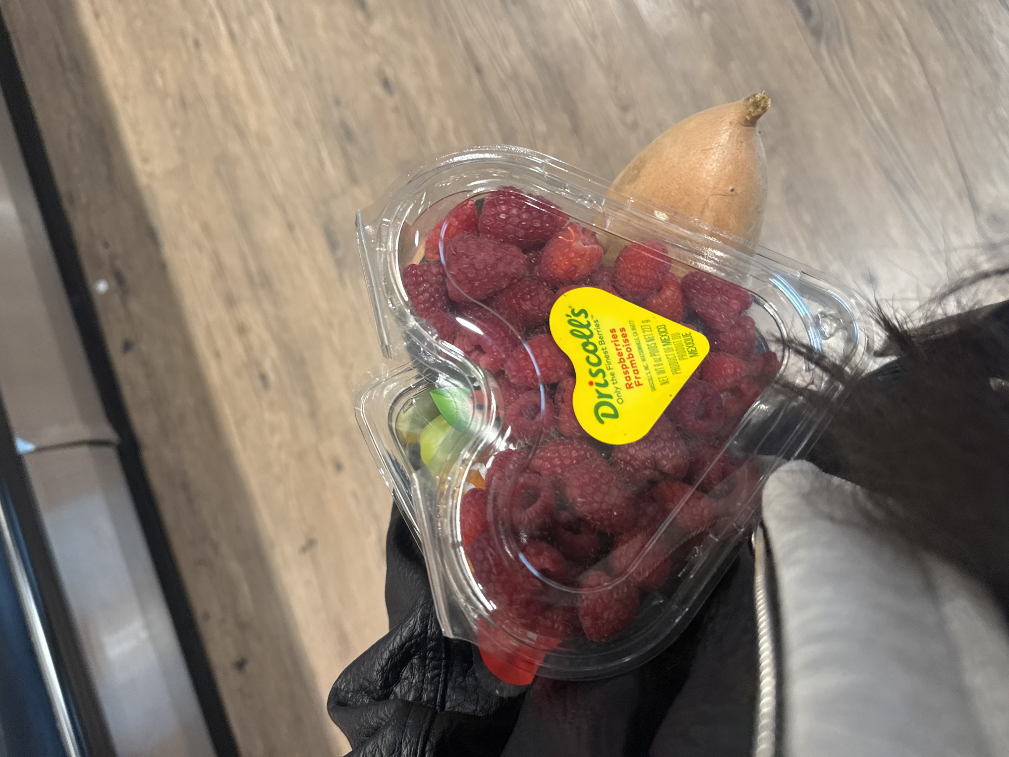 Person holds Mexican raspberries and sweet potato in North Vancouver