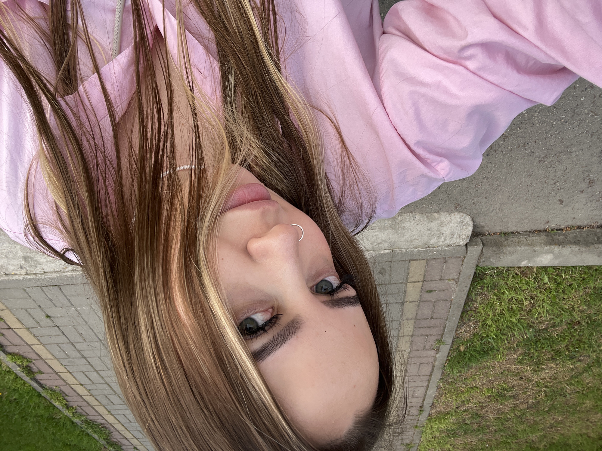 Woman rests on pavement amid spring blooms in Russian town