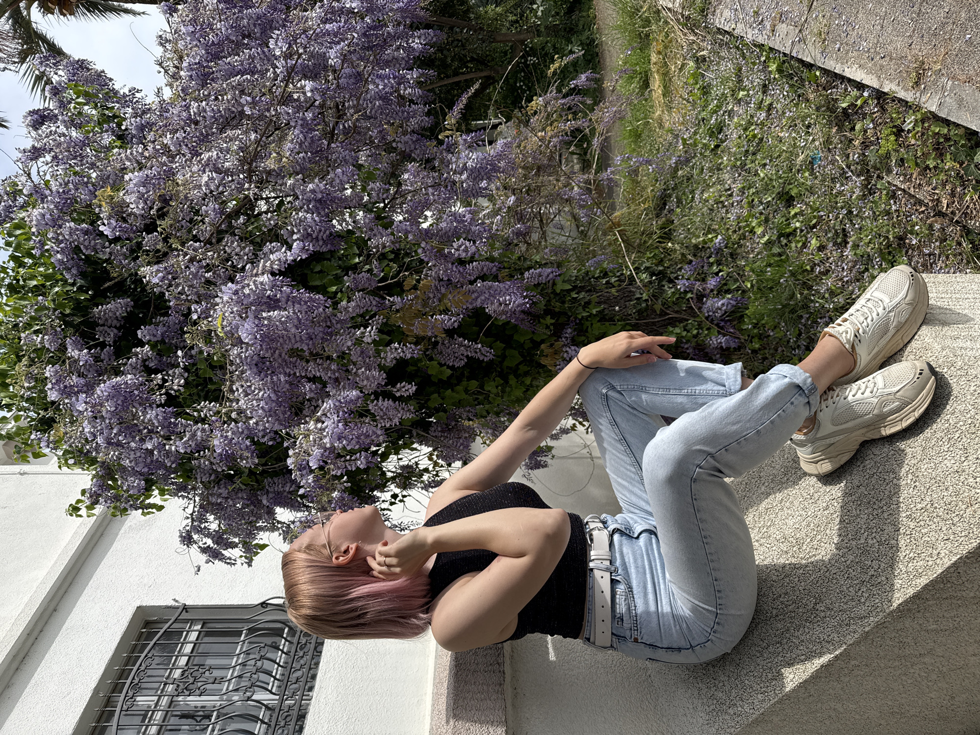 Woman poses with wisteria blossoms in Bar, Montenegro