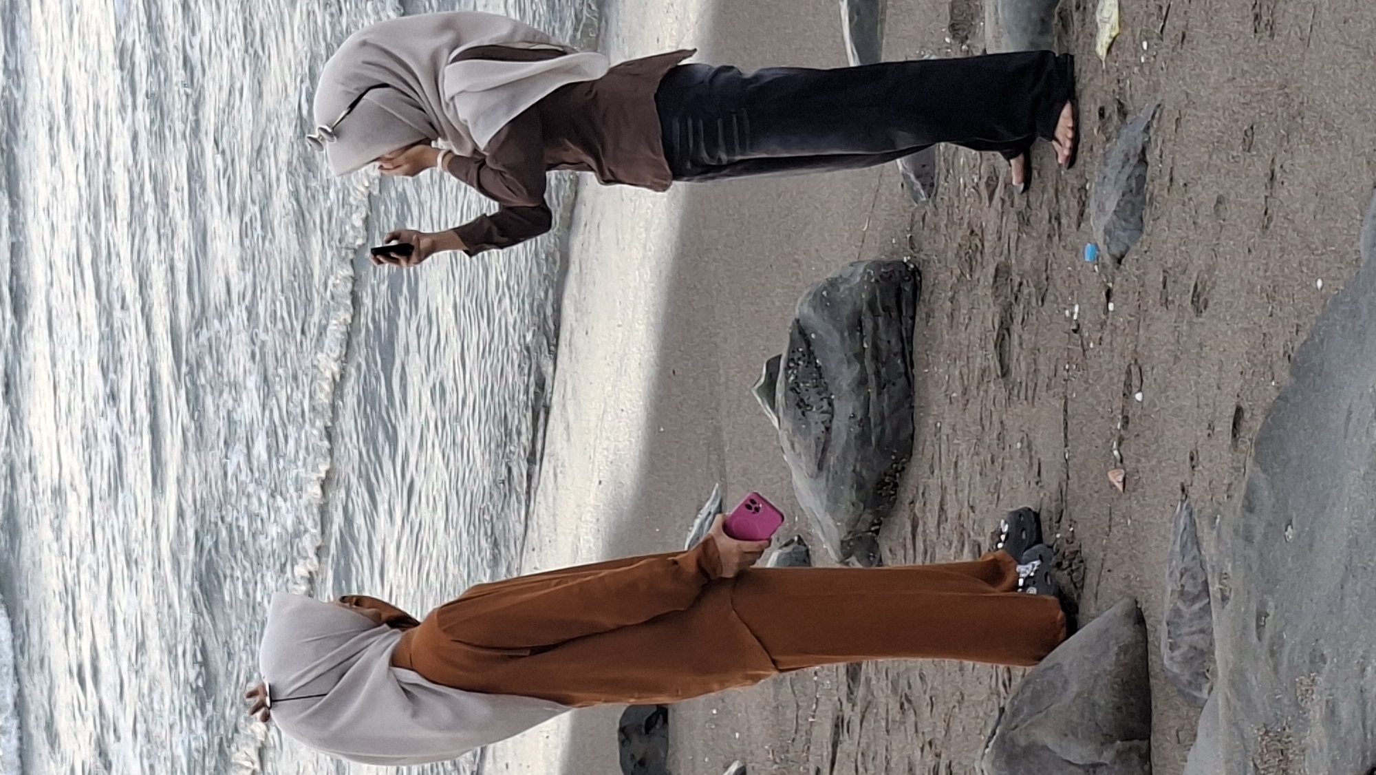 Lhokseumawe beach afternoon: surfers, shoreline hangouts, passing cargo ship