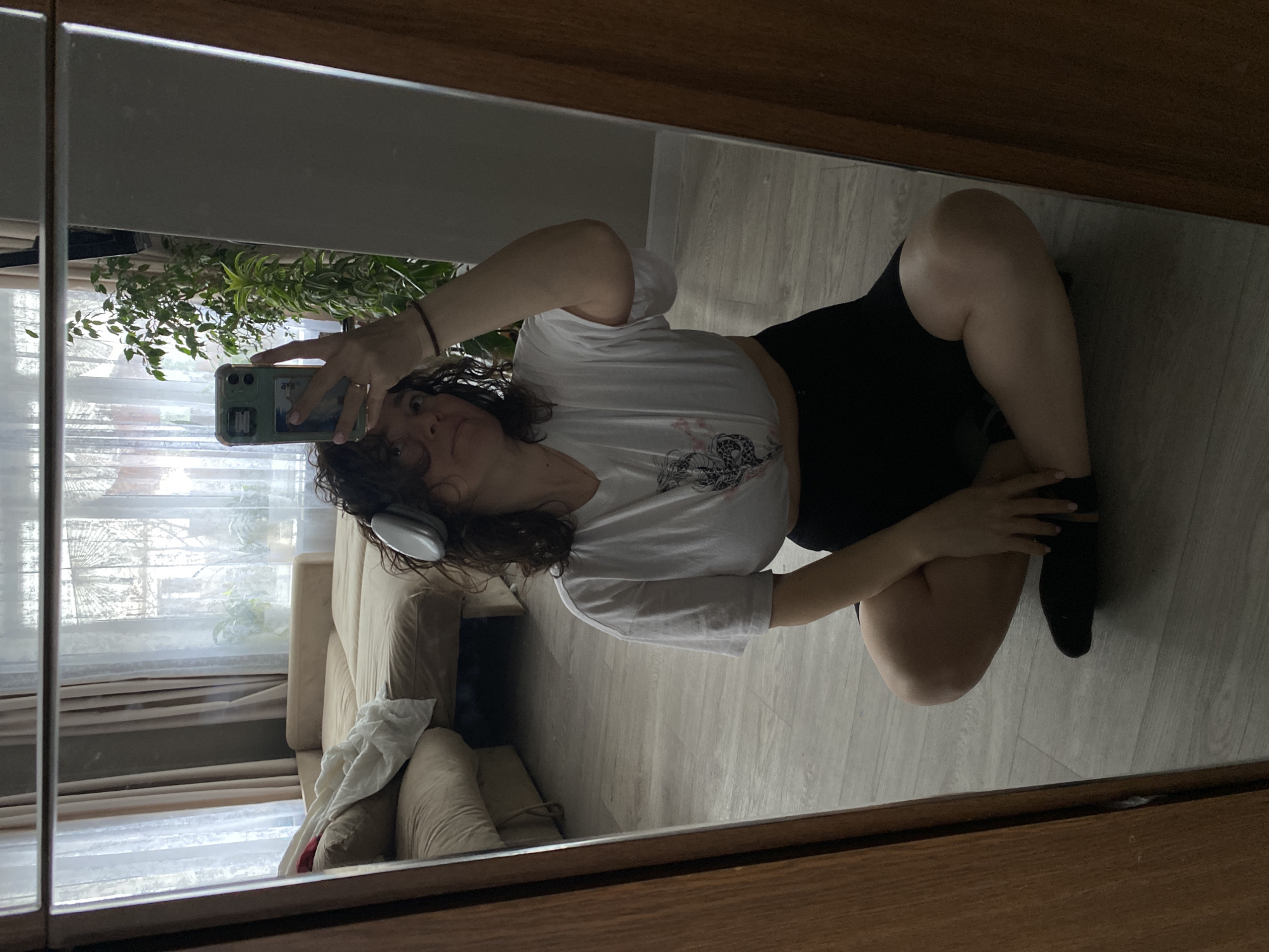 Woman Takes Mirror Selfie on Wooden Floor