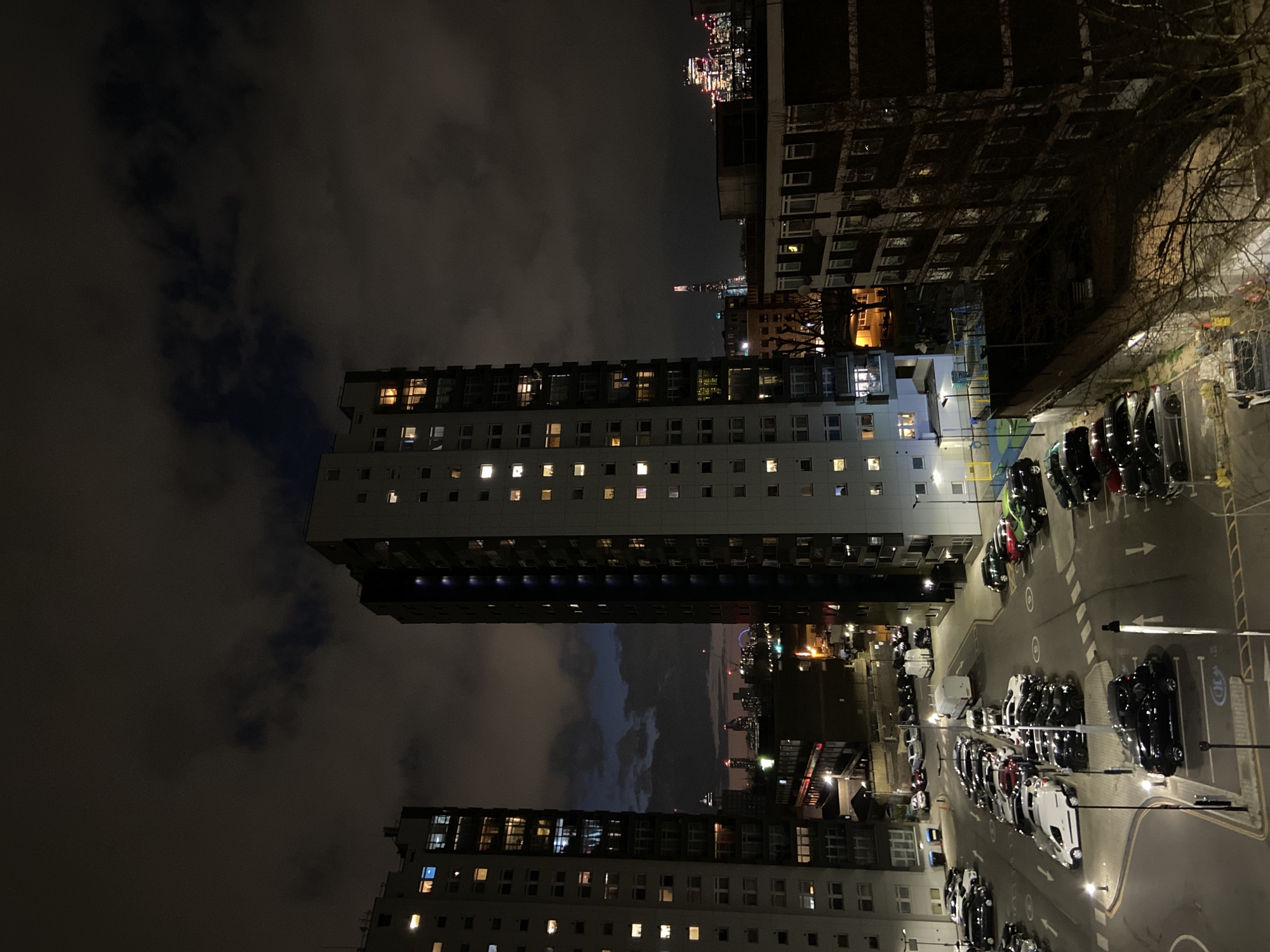 London tower blocks illuminated at night with parking lot