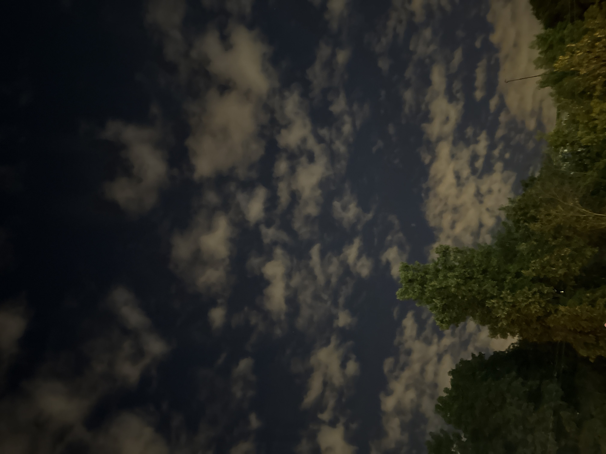 Moscow night sky glowing through scattered clouds near a construction site