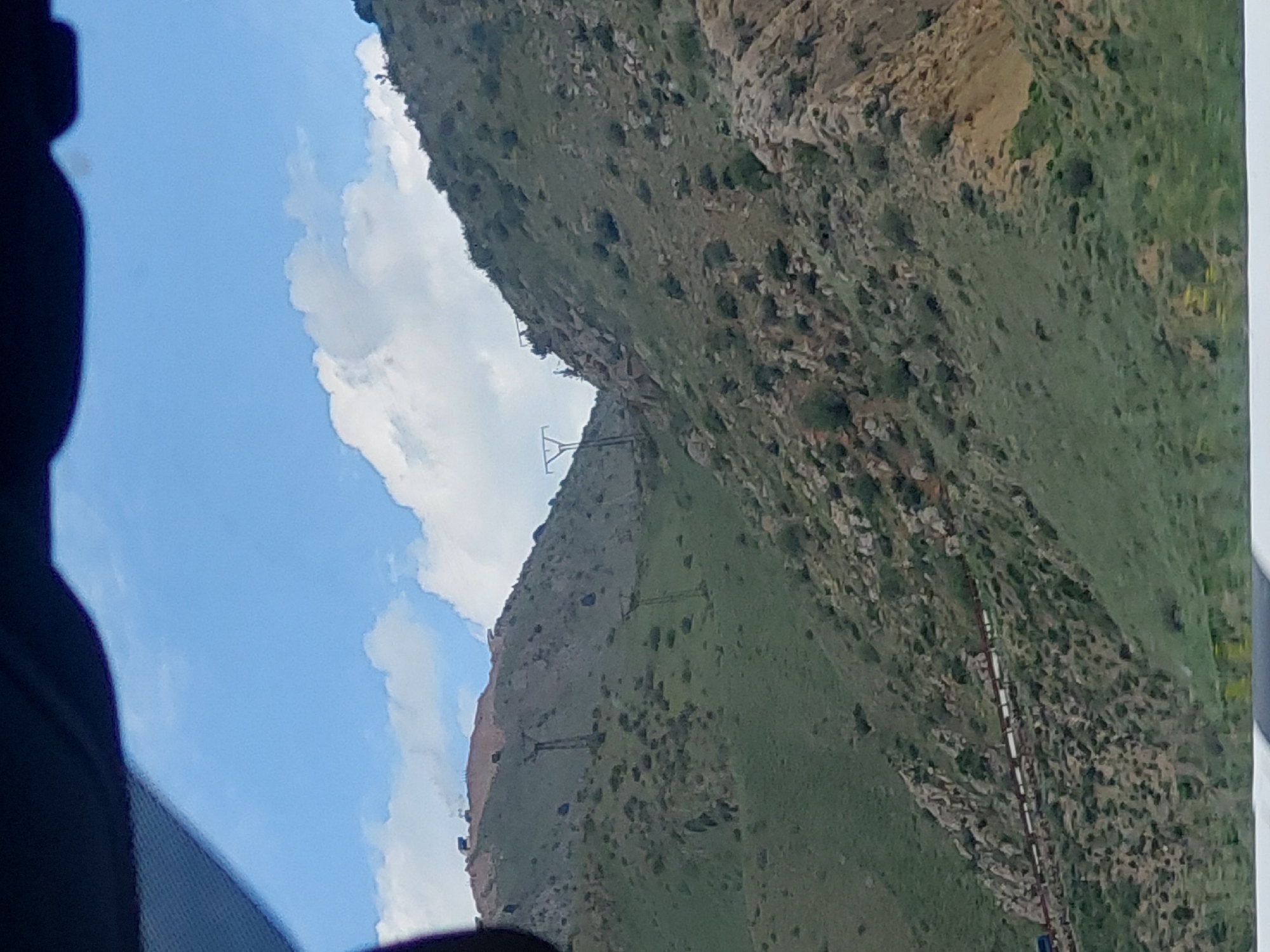 Traveler documents Armenian mountain landscape from moving vehicle
