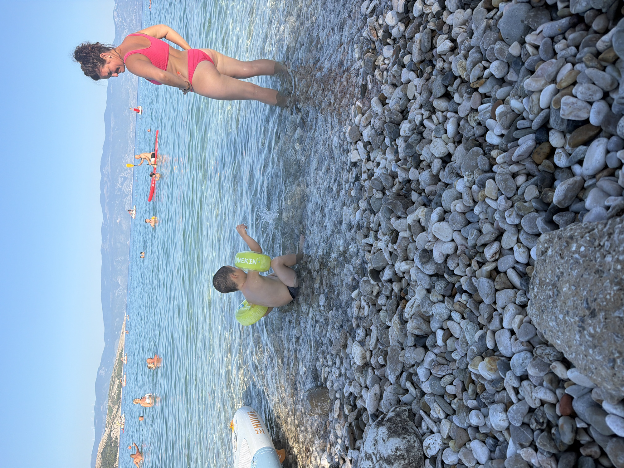 Sunny day on a clear pebble beach in Baška, Croatia
