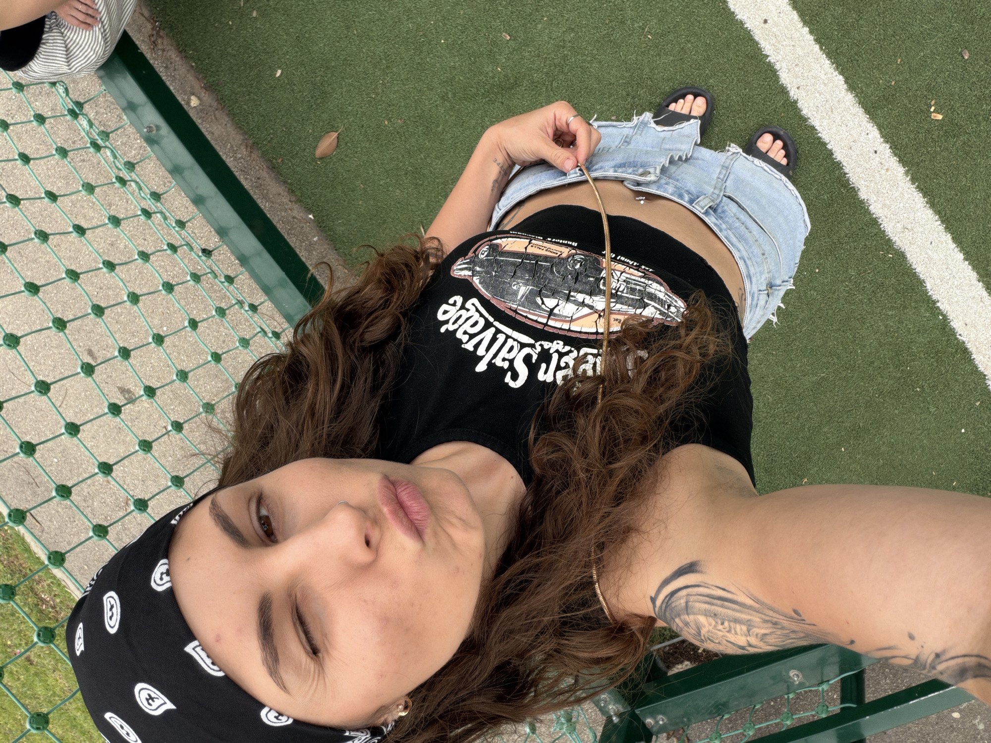 Young woman takes selfies on artificial turf in Kiryat Bialik