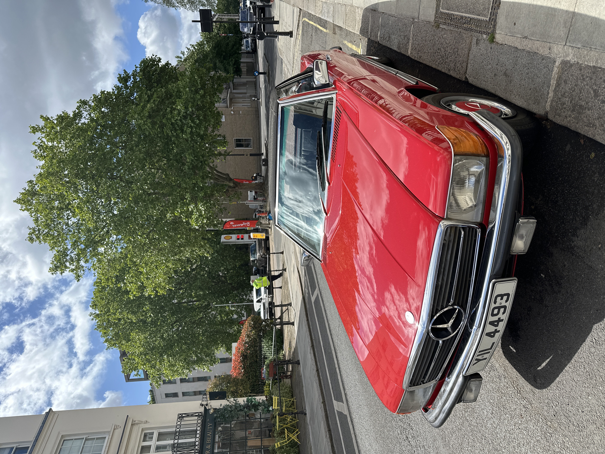 Red Mercedes parked near flower-adorned Bayley shop in London