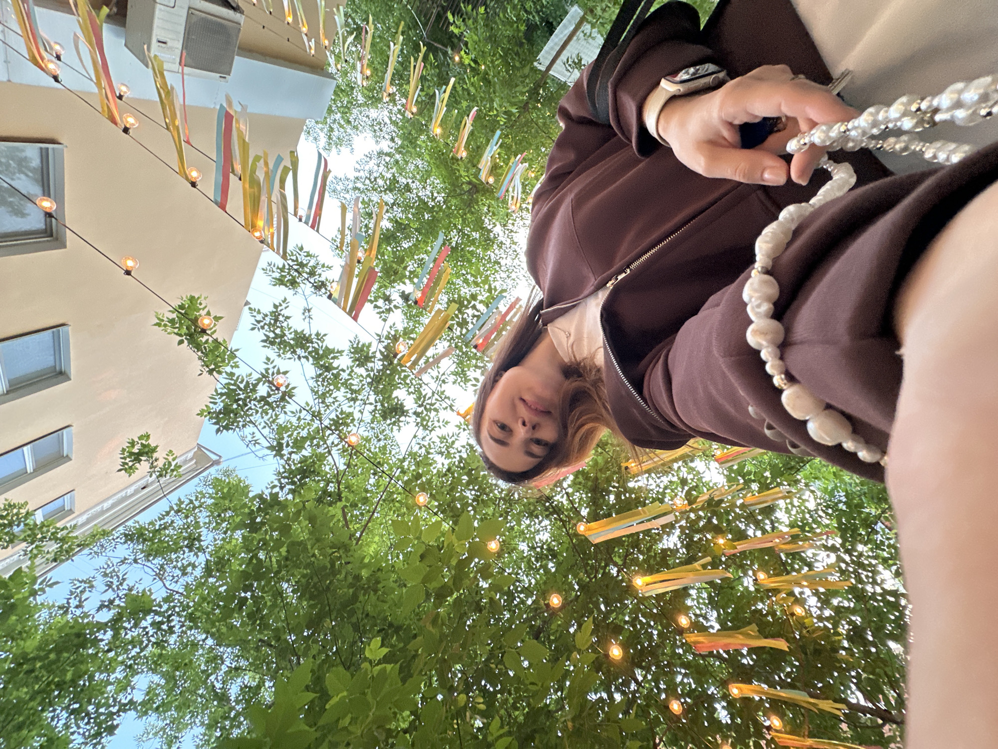 Woman takes selfie in decorated Perm courtyard during evening