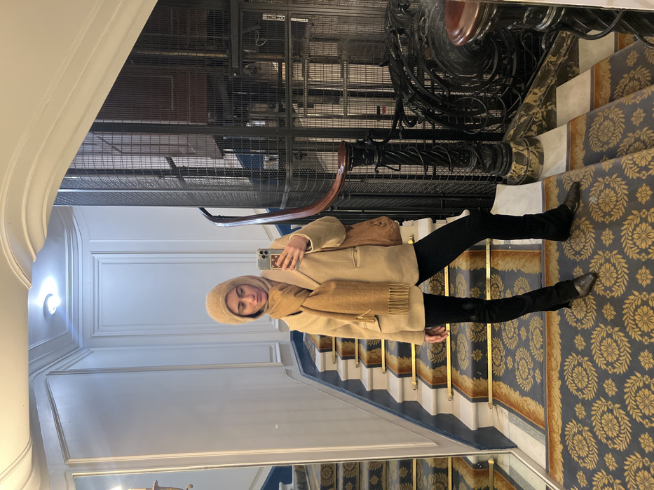 Woman photographs herself on ornate Parisian staircase