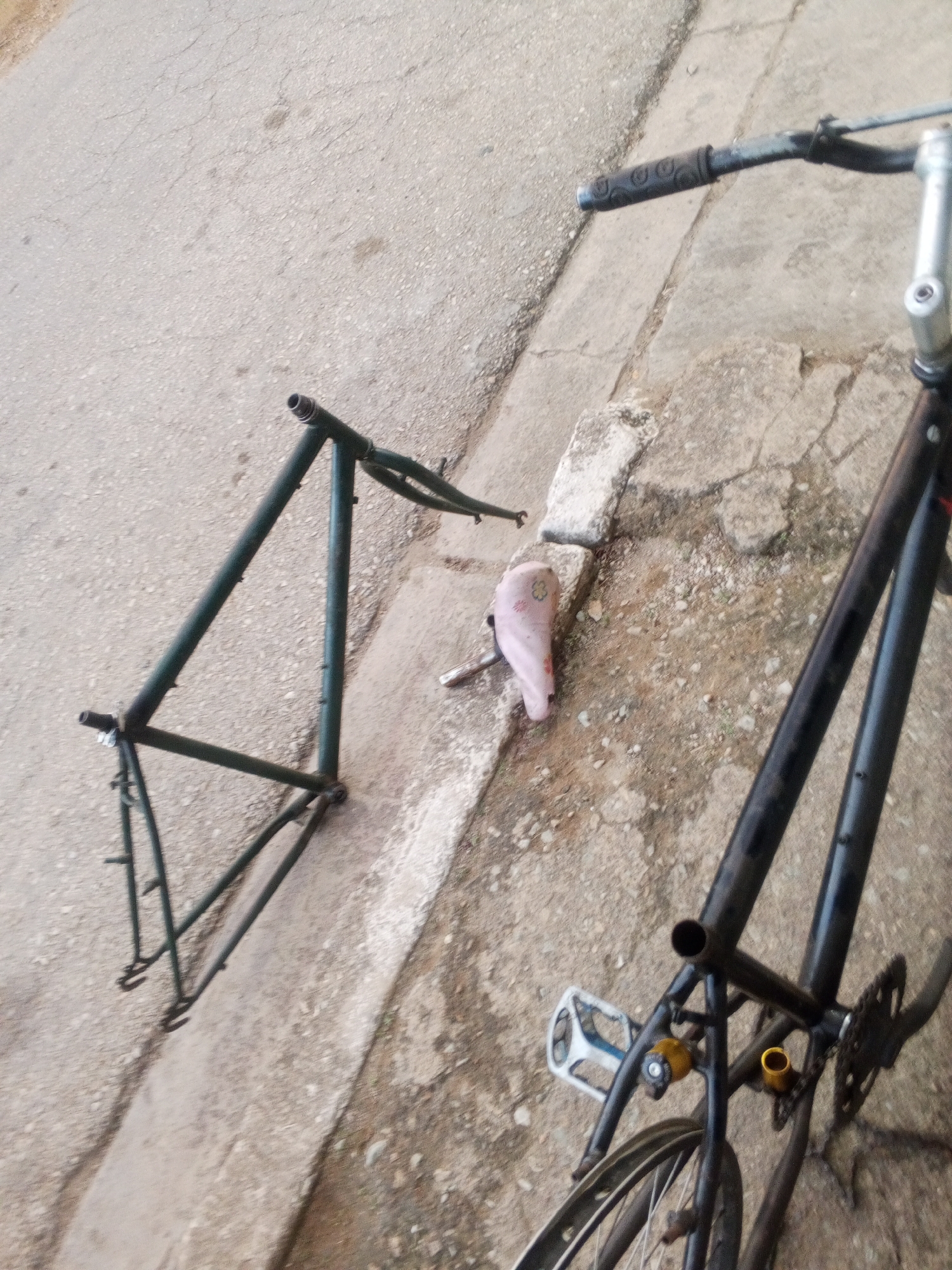 Disassembled bike on cracked pavement under a Venezuela evening sky
