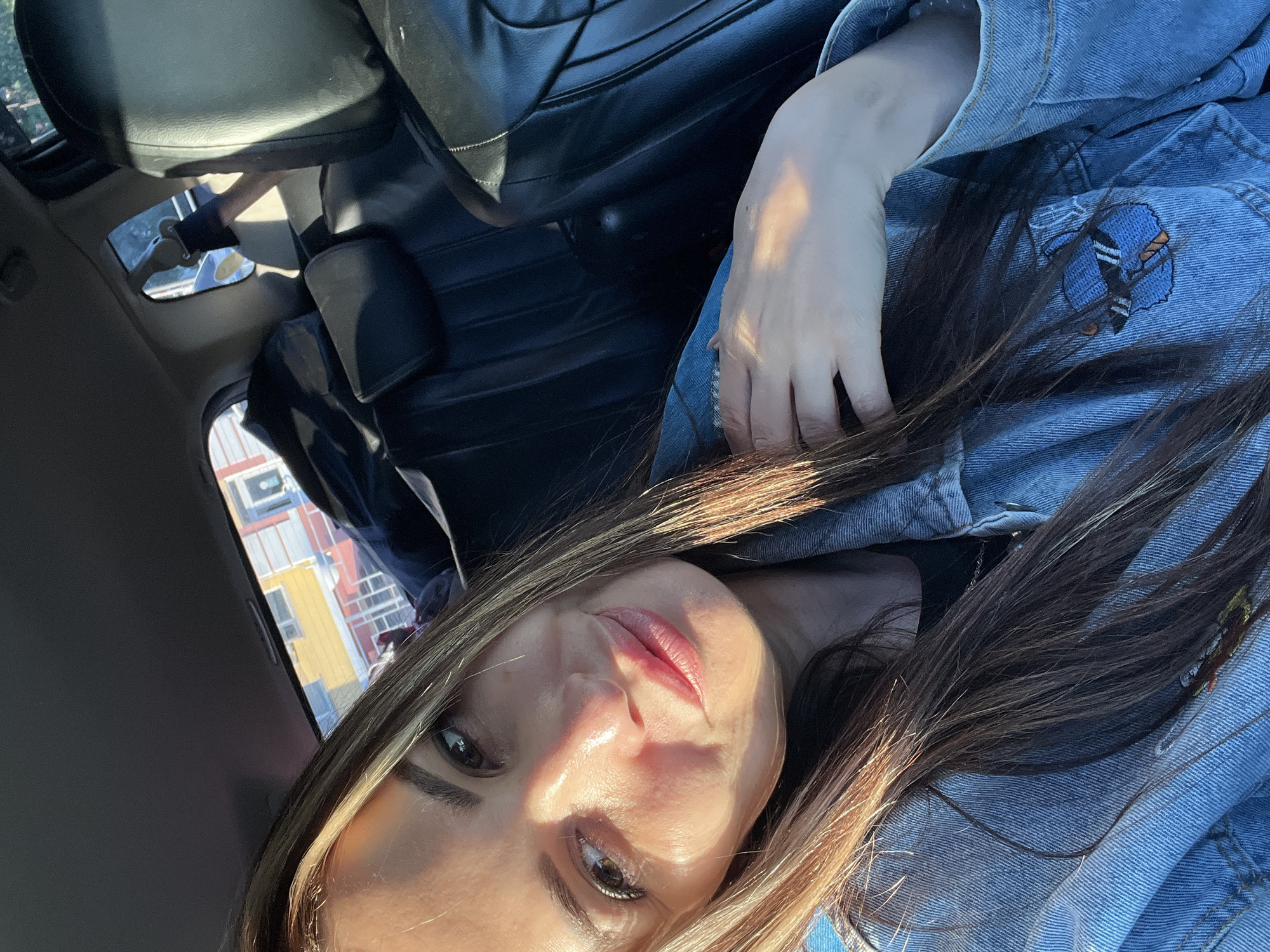 Woman in denim jacket documented during car journey