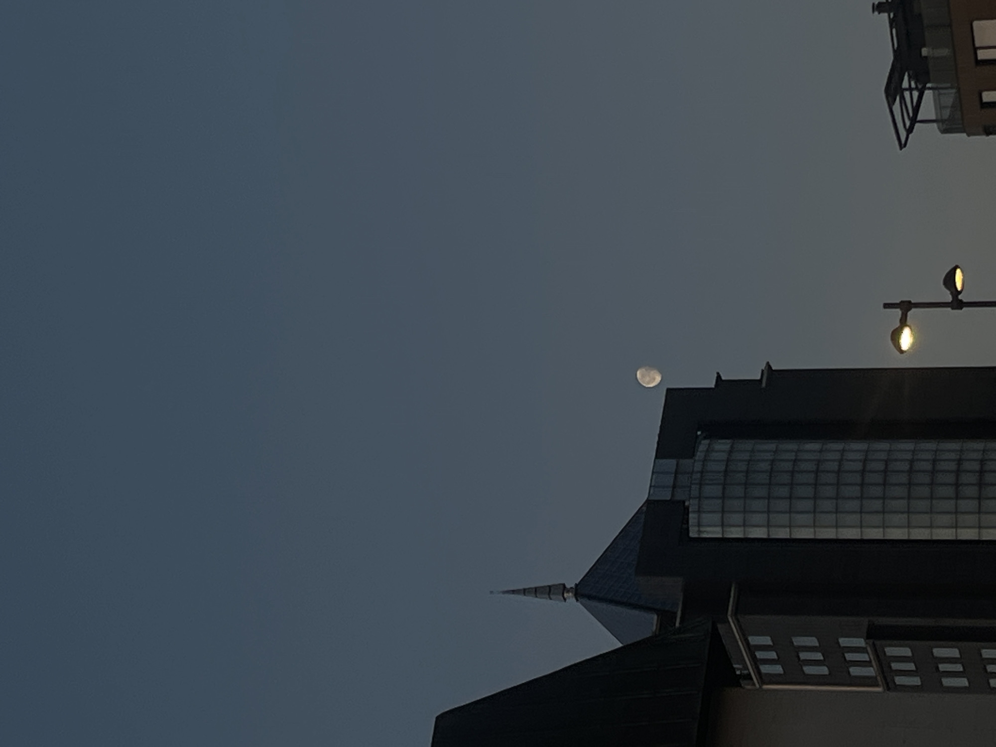 Nearly full moon observed over Plovdiv urban landscape at dawn