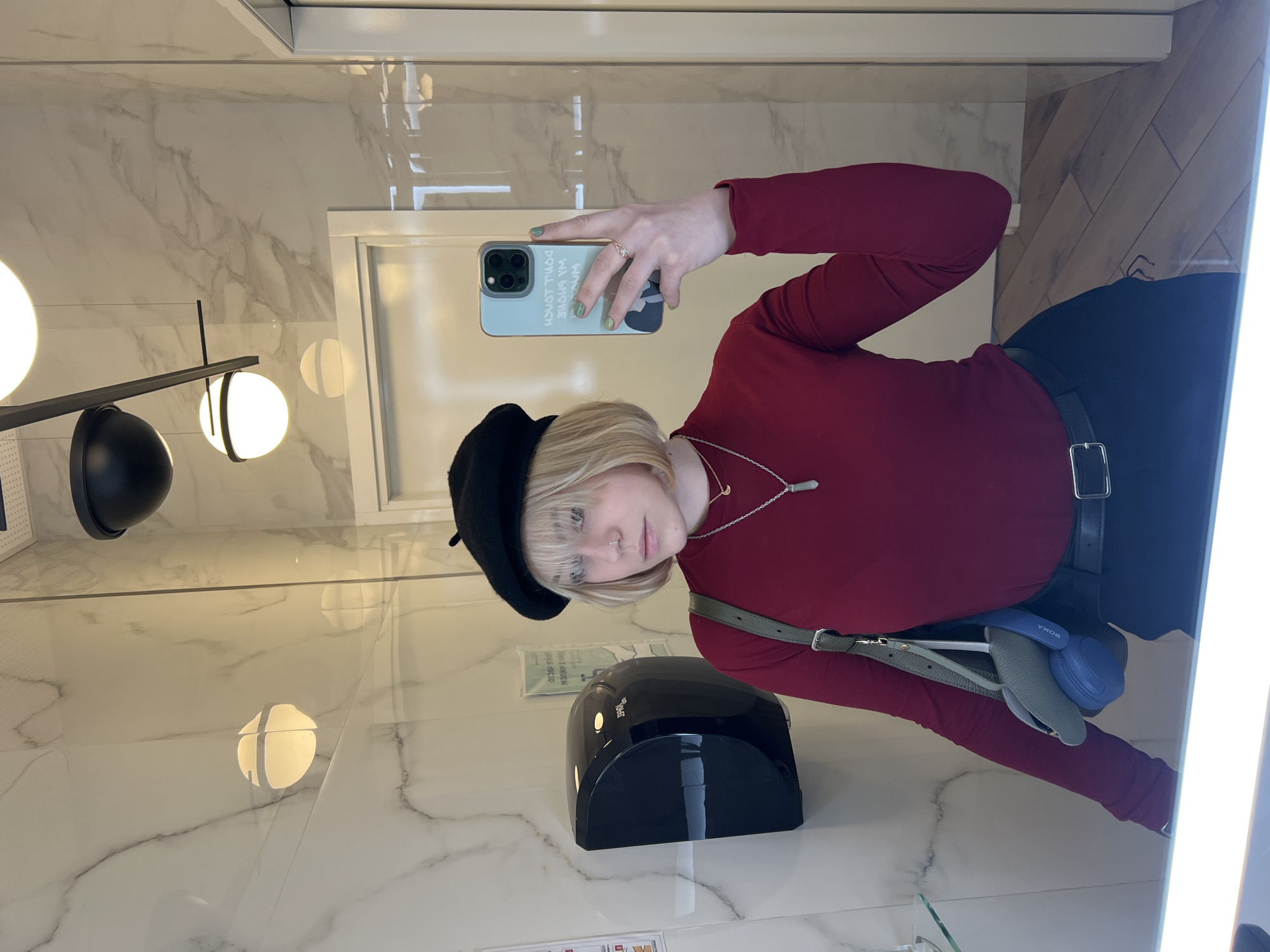 Young person takes mirror selfies in Odesa restroom