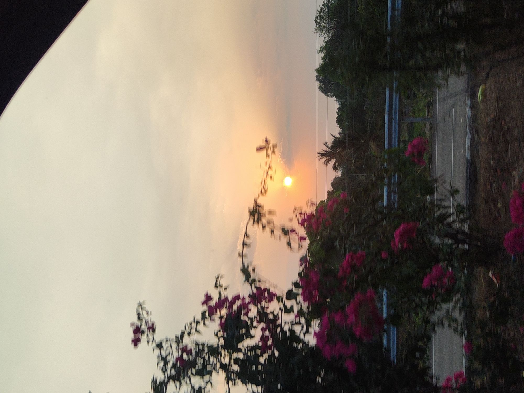 Hazy sunset observed over roadside scene in Aruru, India