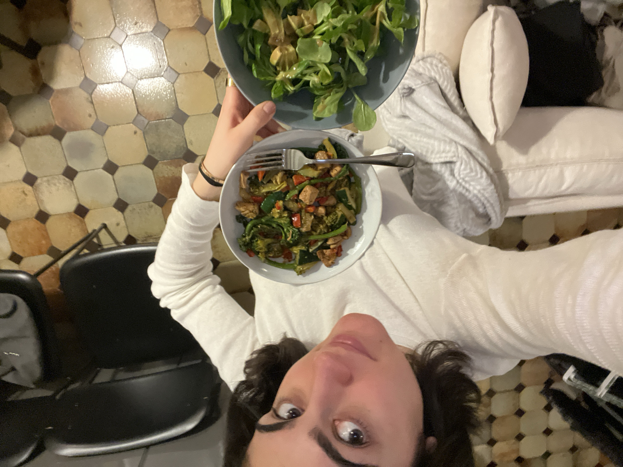 Woman holds two bowls of healthy food in Paris