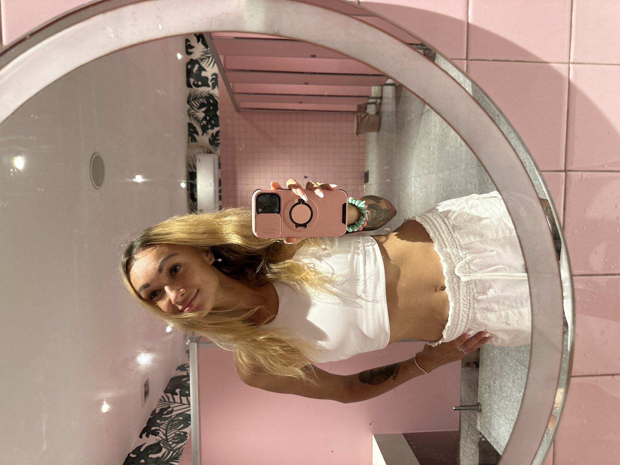 Woman Takes Mirror Selfies in Pink-Decorated Indoor Space