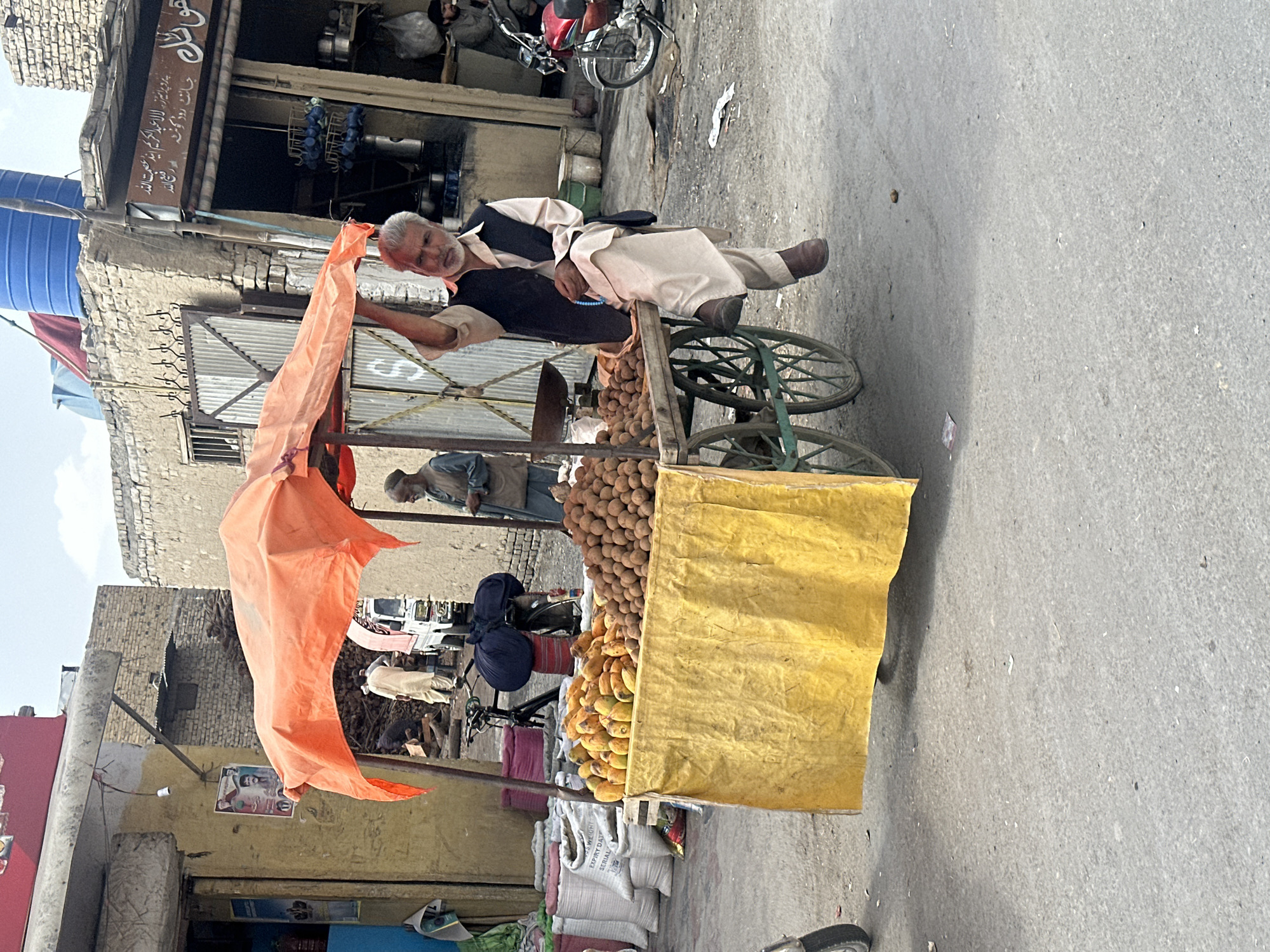 Elderly man rests on fruit cart in Quetta