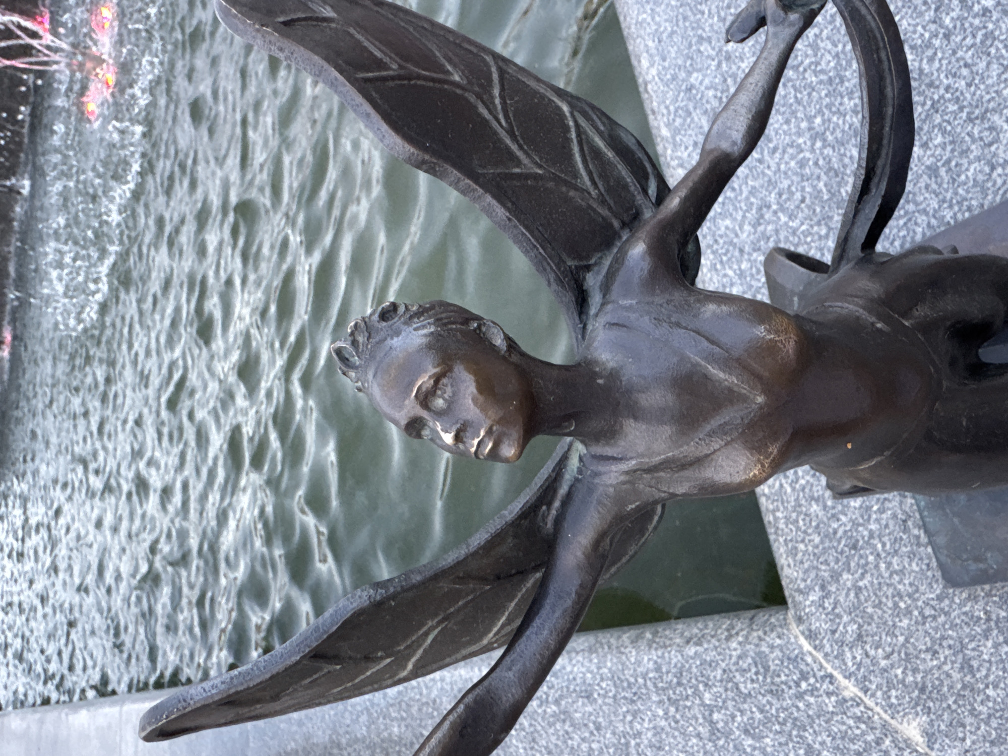 Chaikovsky's fountain square at dusk, lights and bronze wings