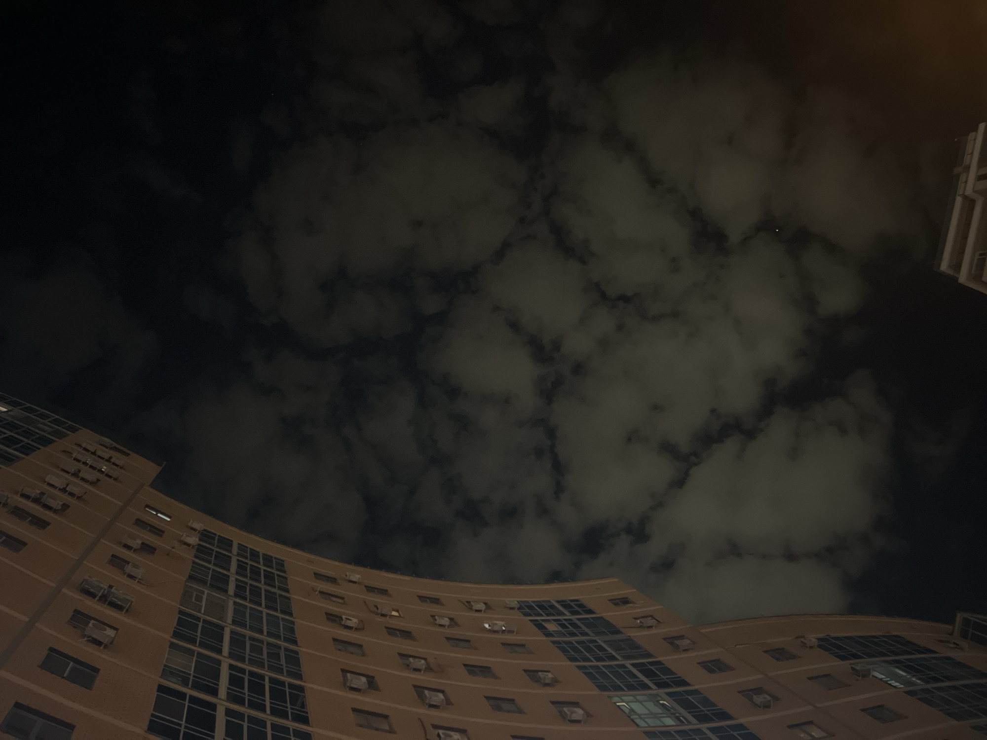 Modern curved building illuminated against night sky in Kazan
