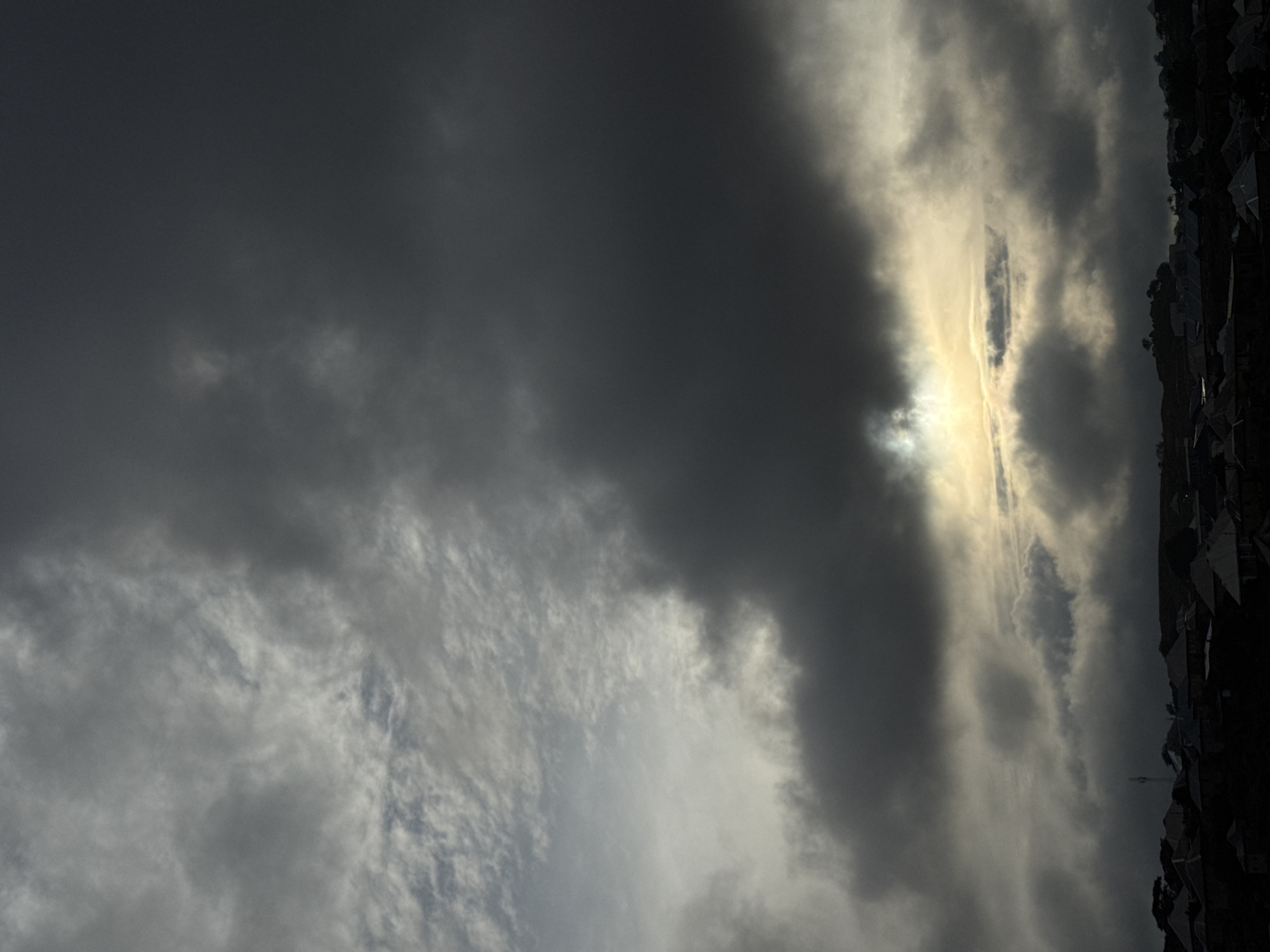 Storm clouds roll over a town as sunlight breaks through
