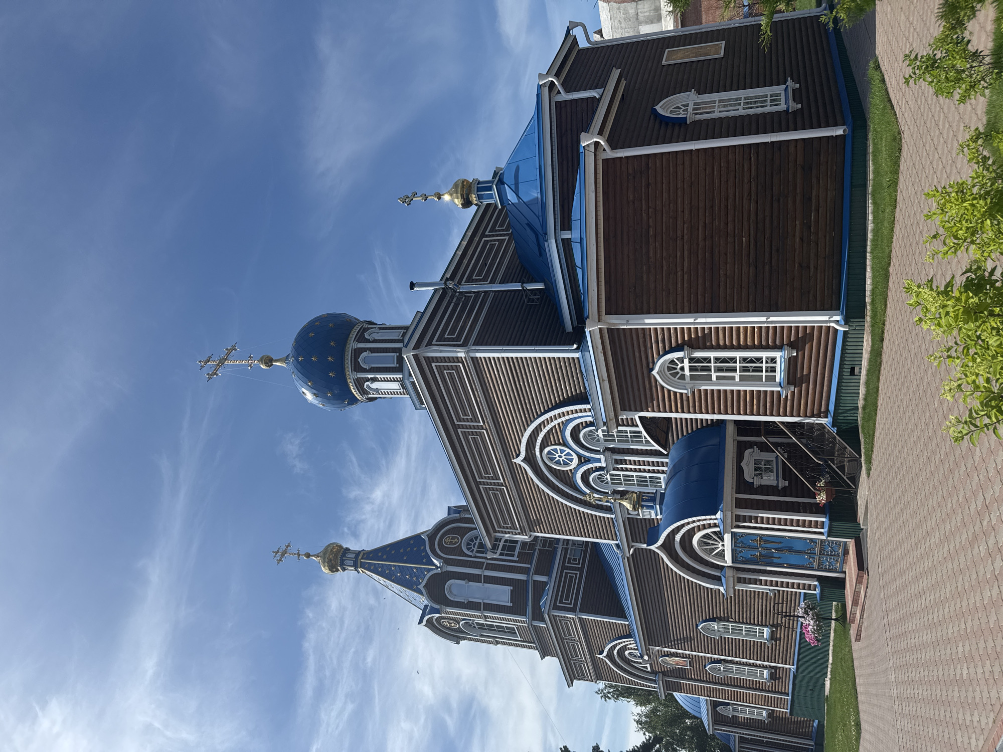Log Orthodox church and garden flowers in Tashla, Russia