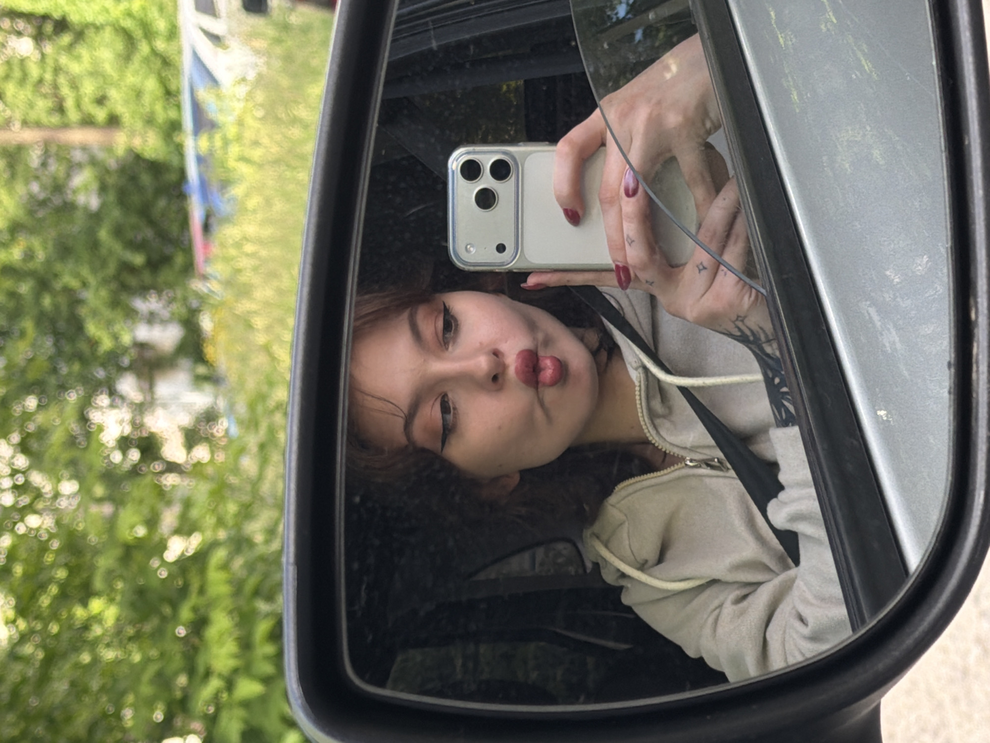Woman takes selfies in car during afternoon photo session