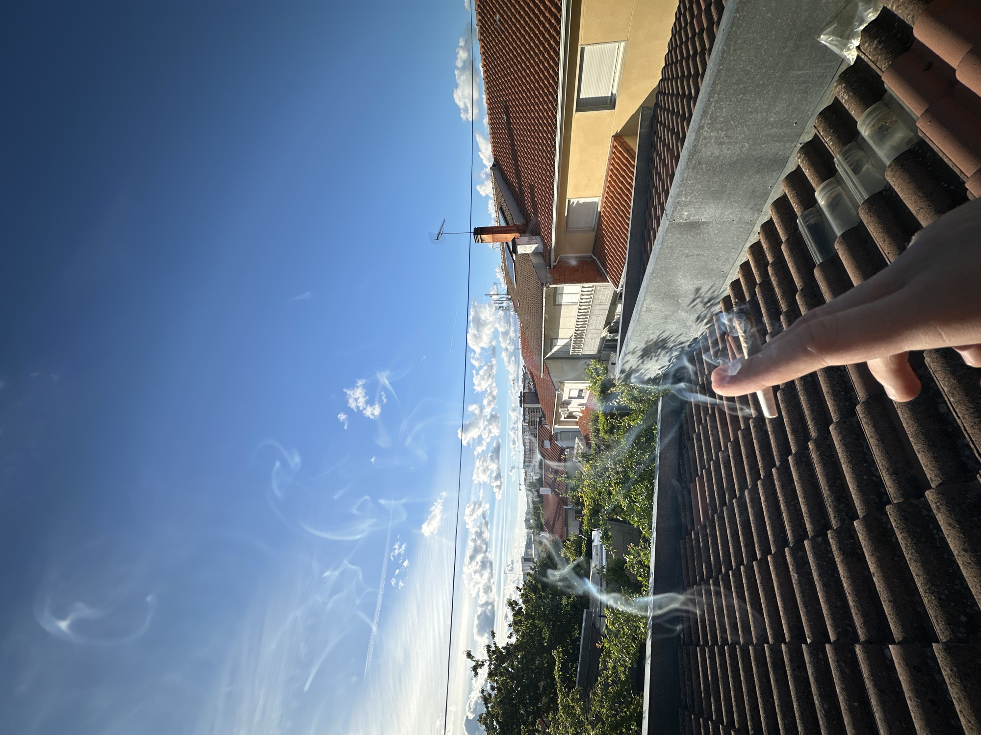 Person smokes cigarette on Bragança rooftop overlooking city