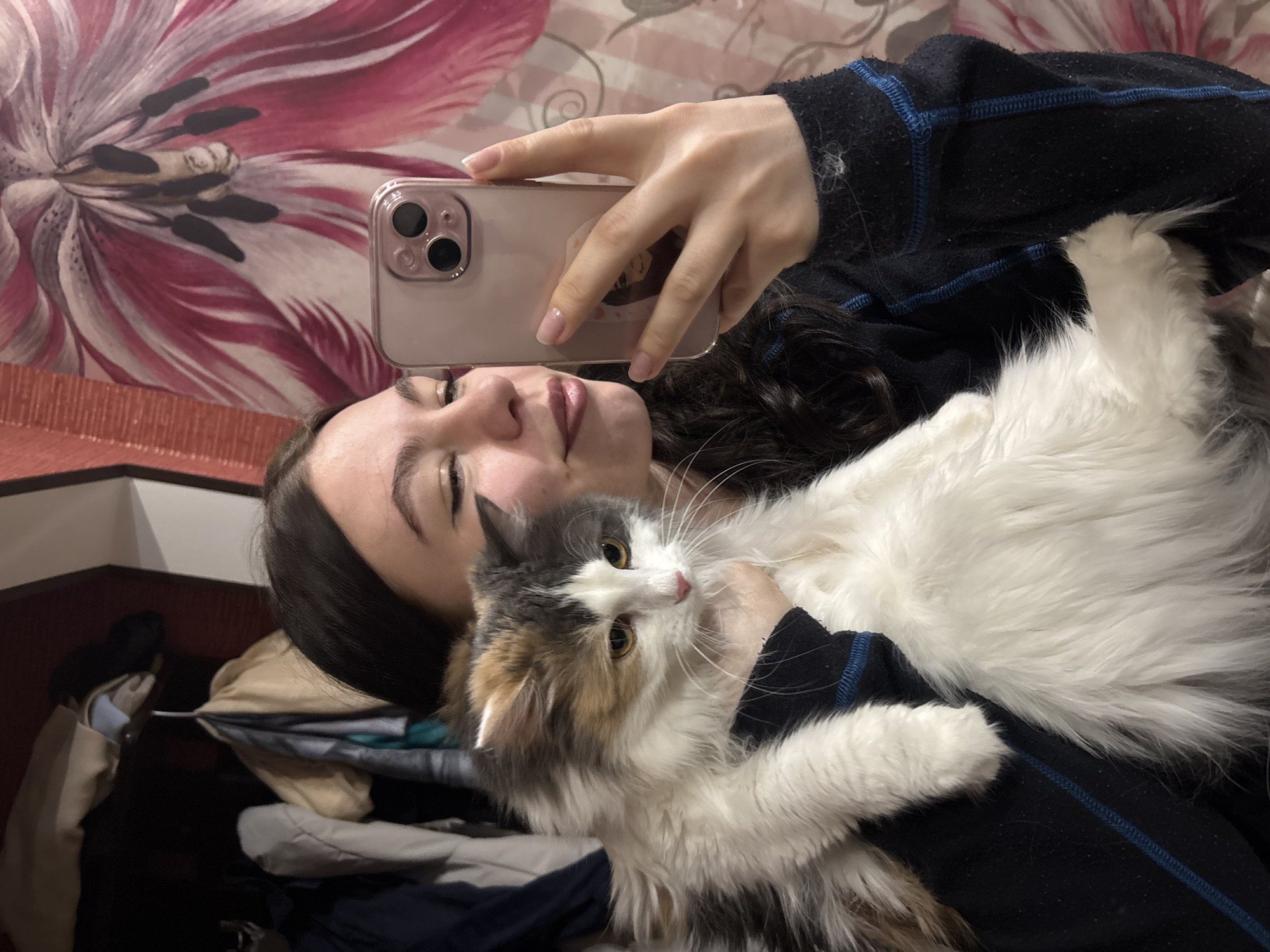 Woman takes selfie with cat in Perm indoor setting
