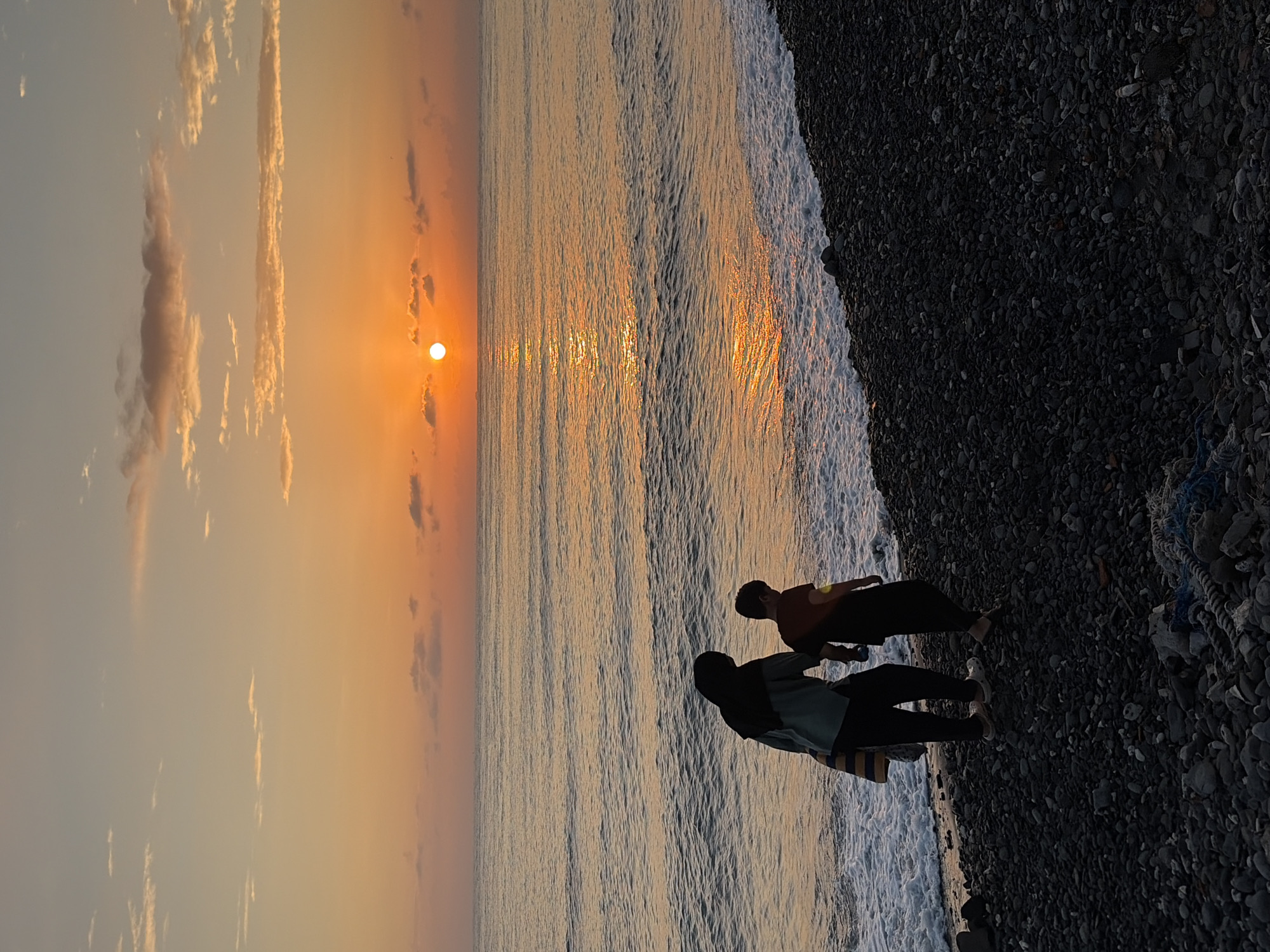 Sunset over the ocean from Abang's pebble beach