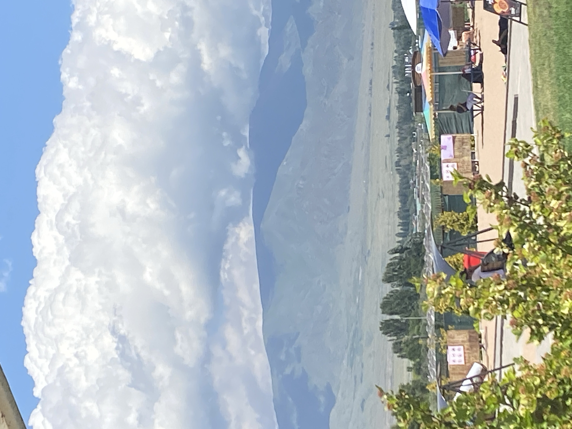 Lakeside park in Koshkol' with mountain backdrop, sunny morning