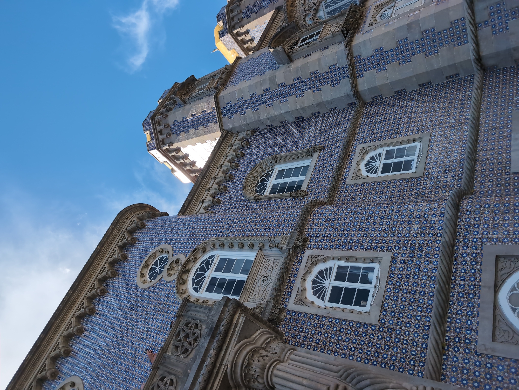 Tourist photographs Pena Palace's colorful architecture in Sintra