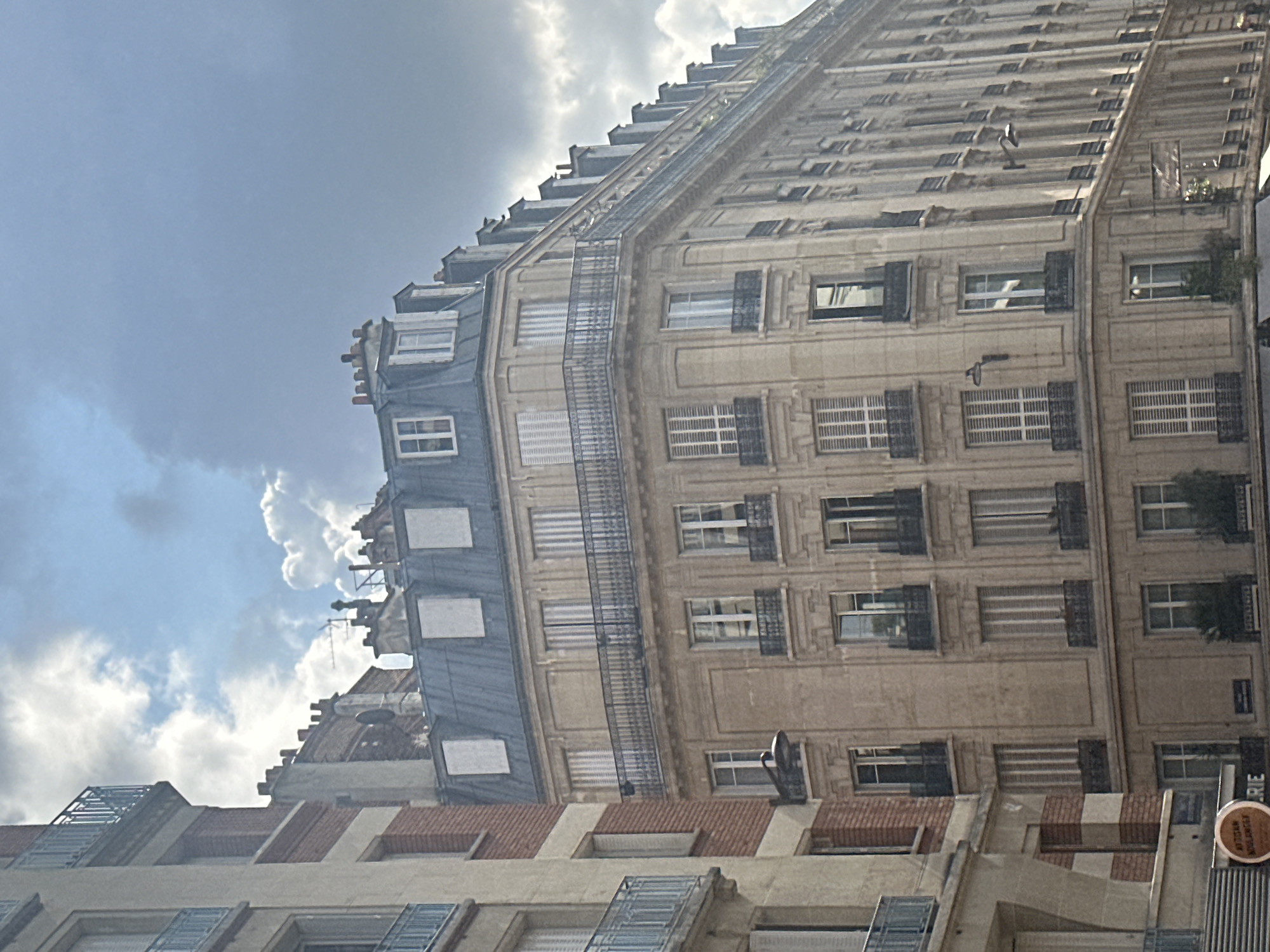 Mixed Haussmannian and brick architecture on a Paris street corner