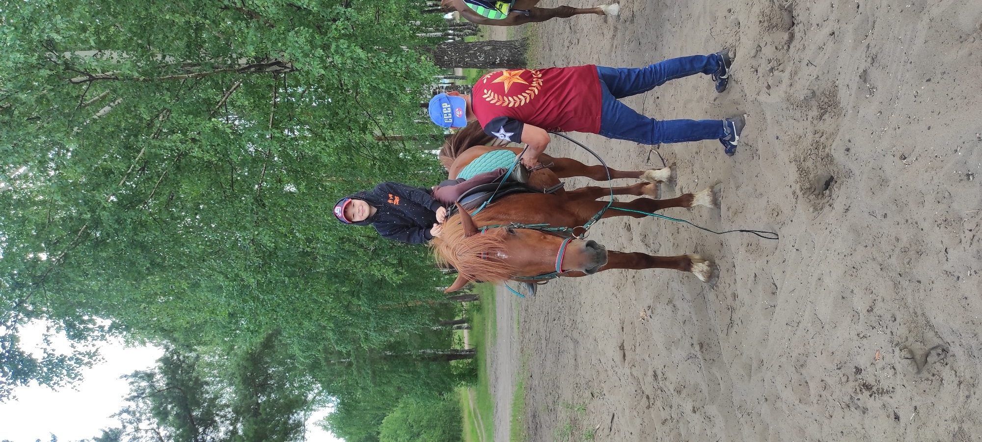 Horseback riding on a sandy riverside clearing in rural Russia