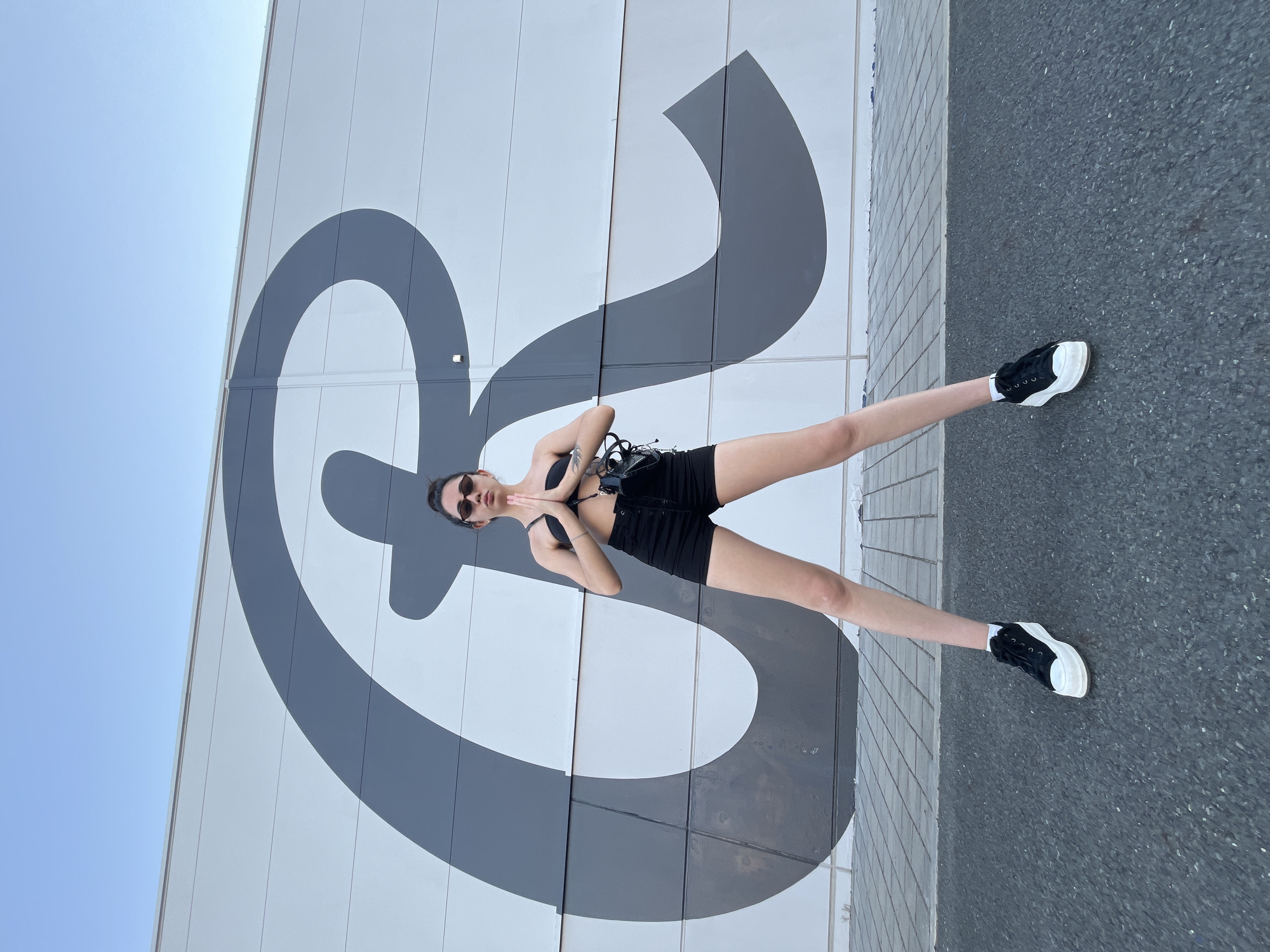 Posing and playing around a bold 'R' mural in Pilsen