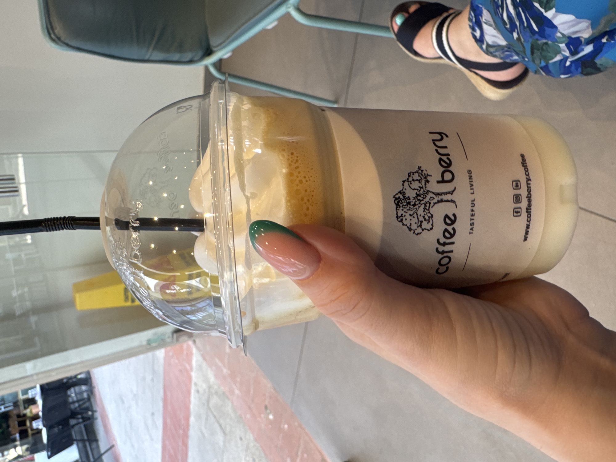 Person holds Coffeeberry branded coffee cup in Larnaca