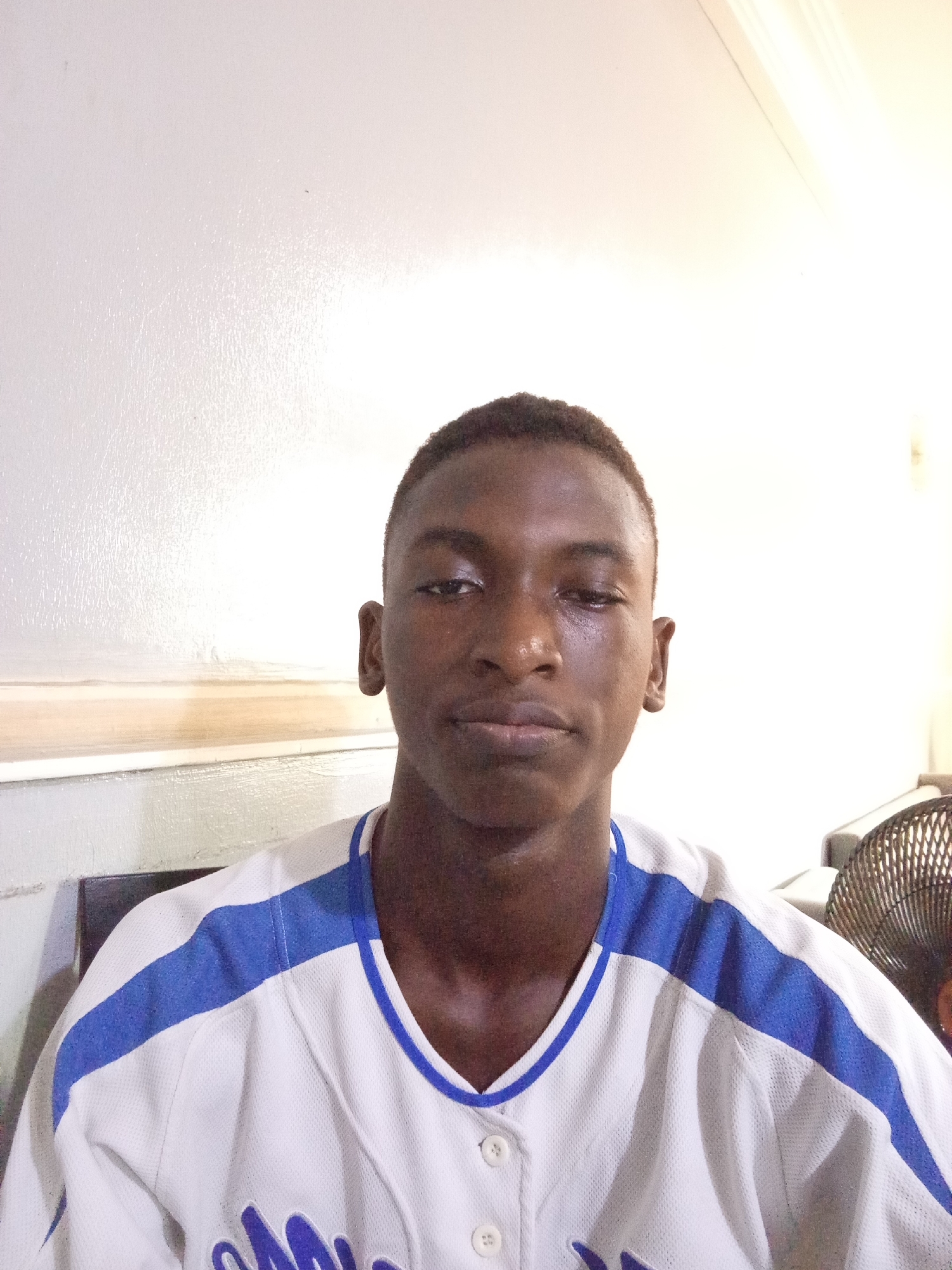 Young man in baseball jersey photographed at location